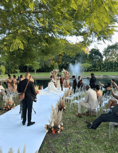 Lakeside wedding ceremony at a private South Florida estate with pampas décor and elegant floral accents.