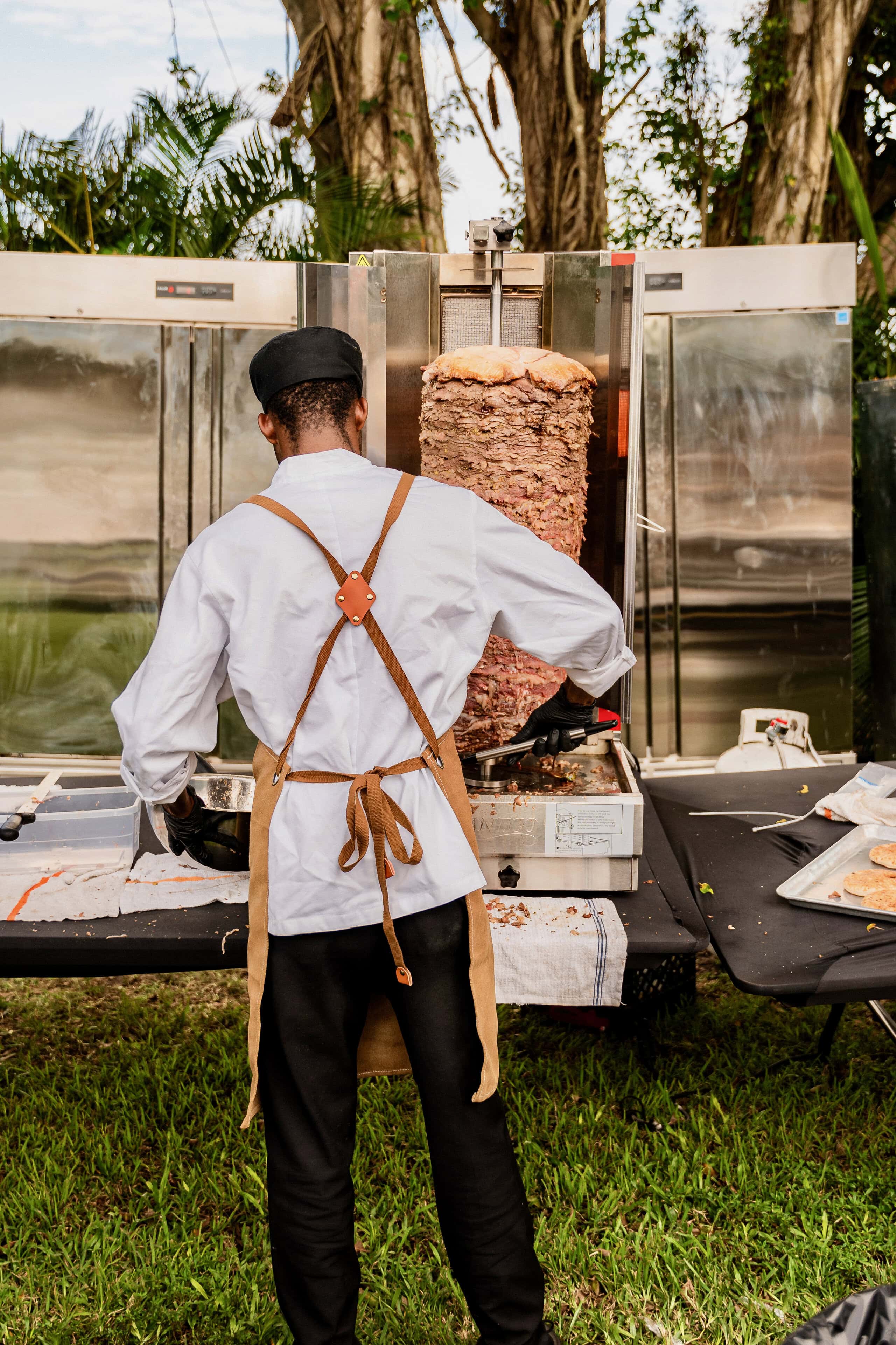 Chef carving shawarma at live wedding catering station