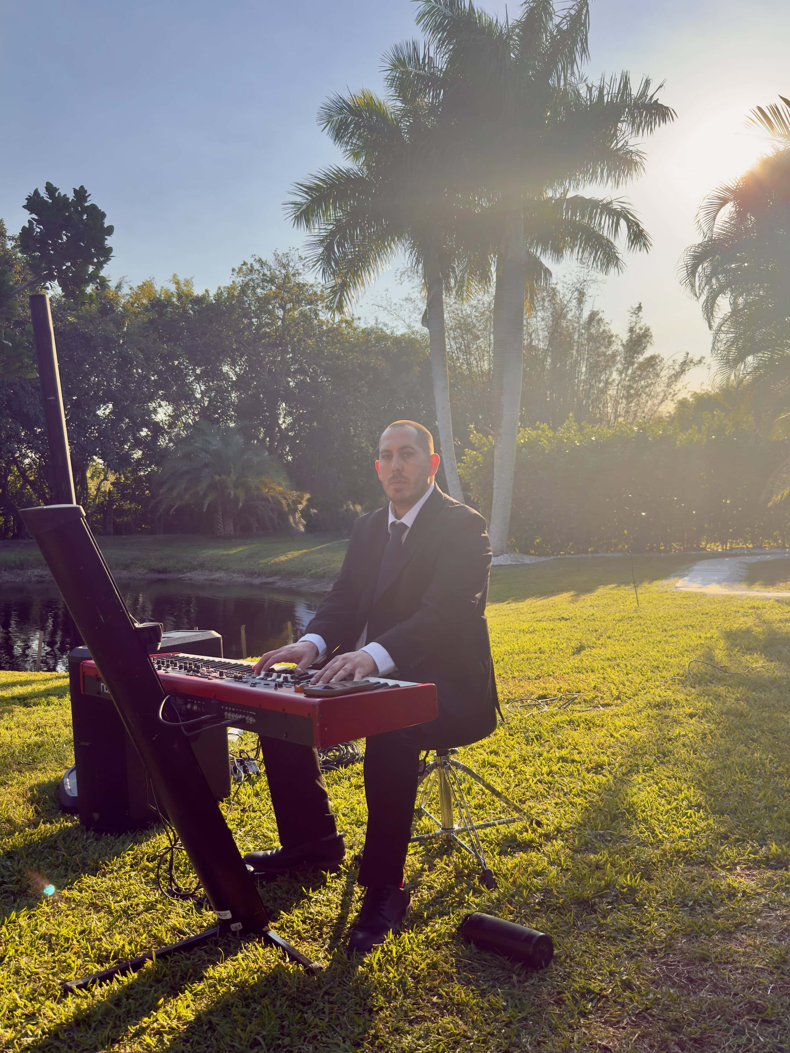 Keyboardist performing live music at an outdoor wedding ceremony at Saint Patrick Palace.