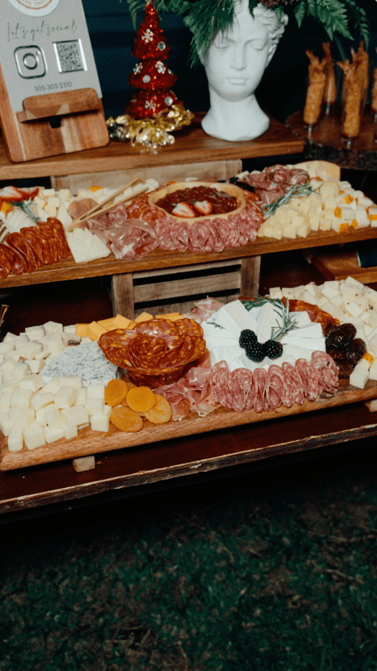 Luxury Christmas charcuterie display with assorted cheeses, cured meats, salami, fruit, and wooden serving boards.