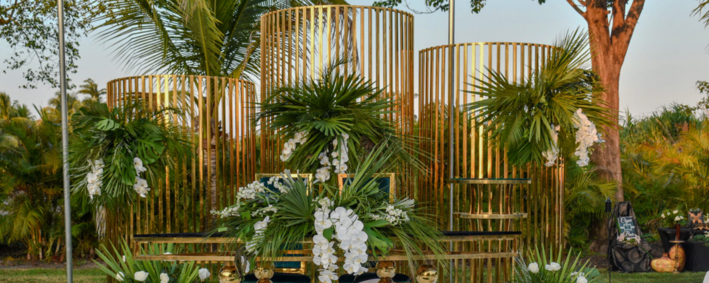 Gold geometric structures with tropical greenery and white orchids at a luxury private estate wedding in Davie.