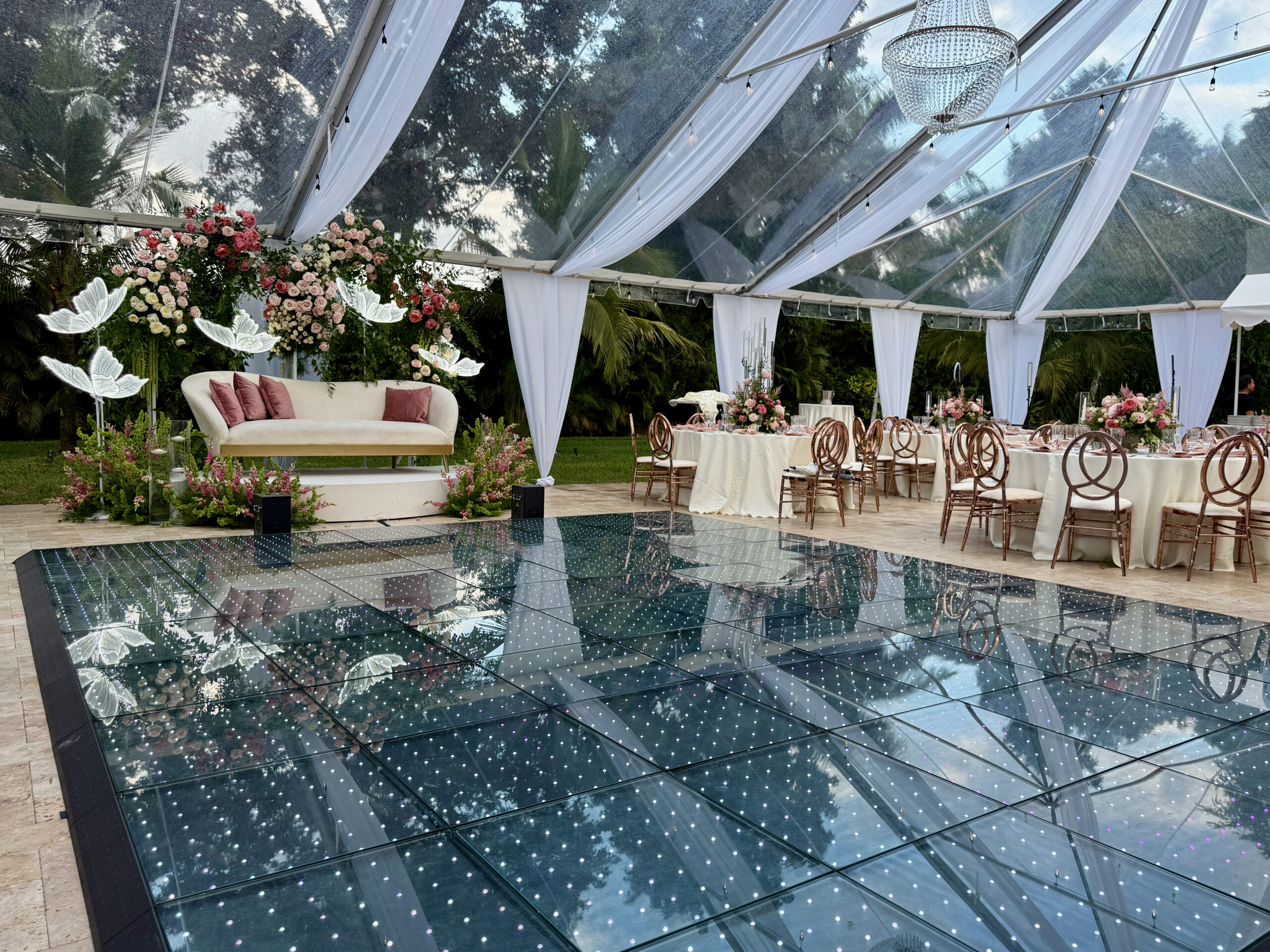 LED dance floor reflecting chandelier at elegant South Florida quinceañera.