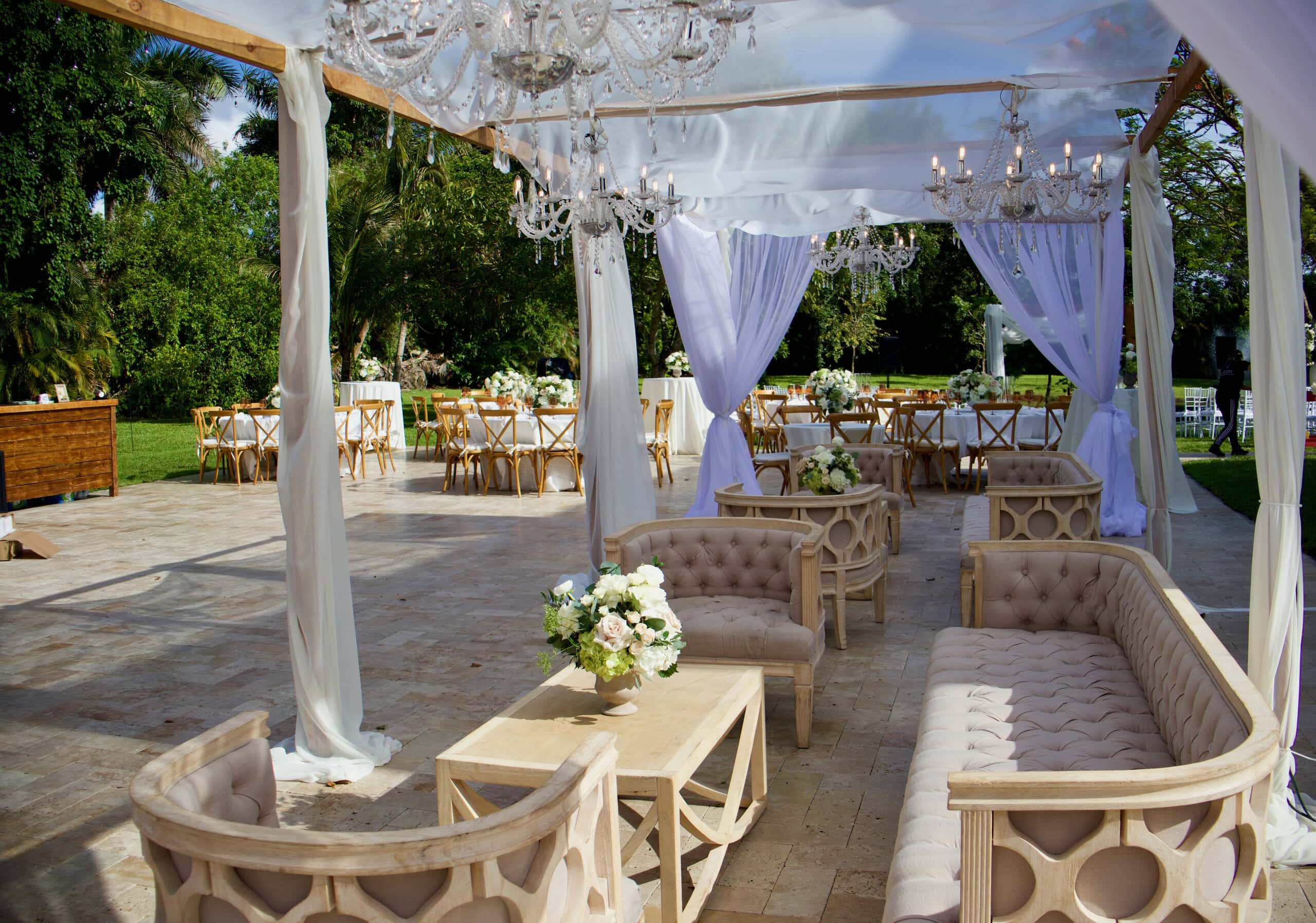 Luxury wedding lounge with white draping, crystal chandeliers, and elegant seating at Saint Patrick Palace.
