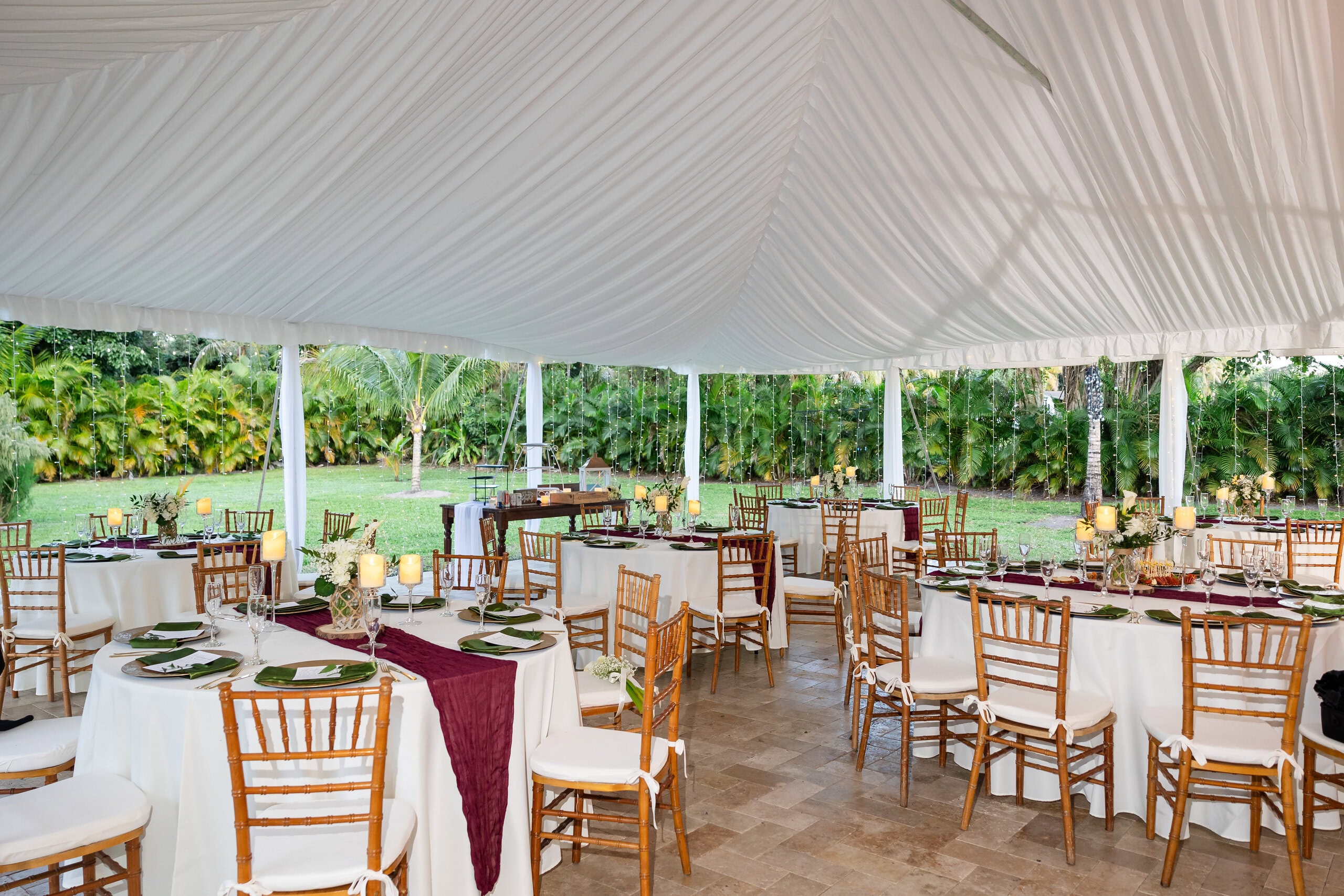 Elegant outdoor wedding reception under a draped white tent at Saint Patrick Palace in South Florida.