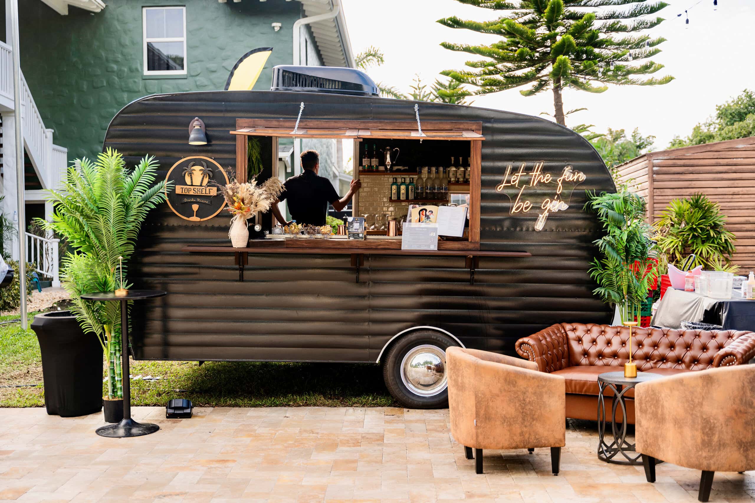 Mobile cocktail bar trailer serving drinks at outdoor wedding reception