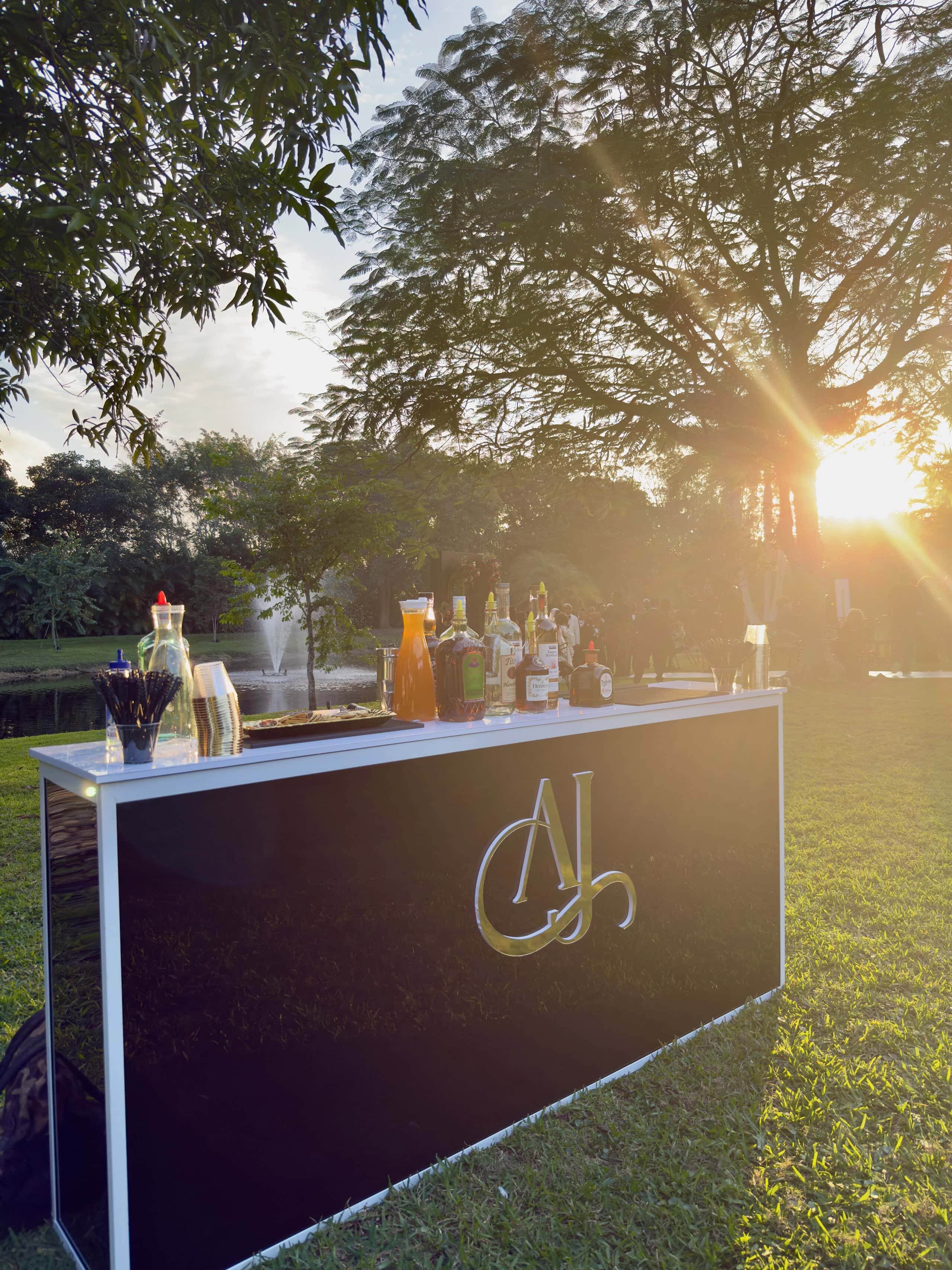 Custom outdoor bar at sunset during a modern black-tie garden glam wedding in South Florida