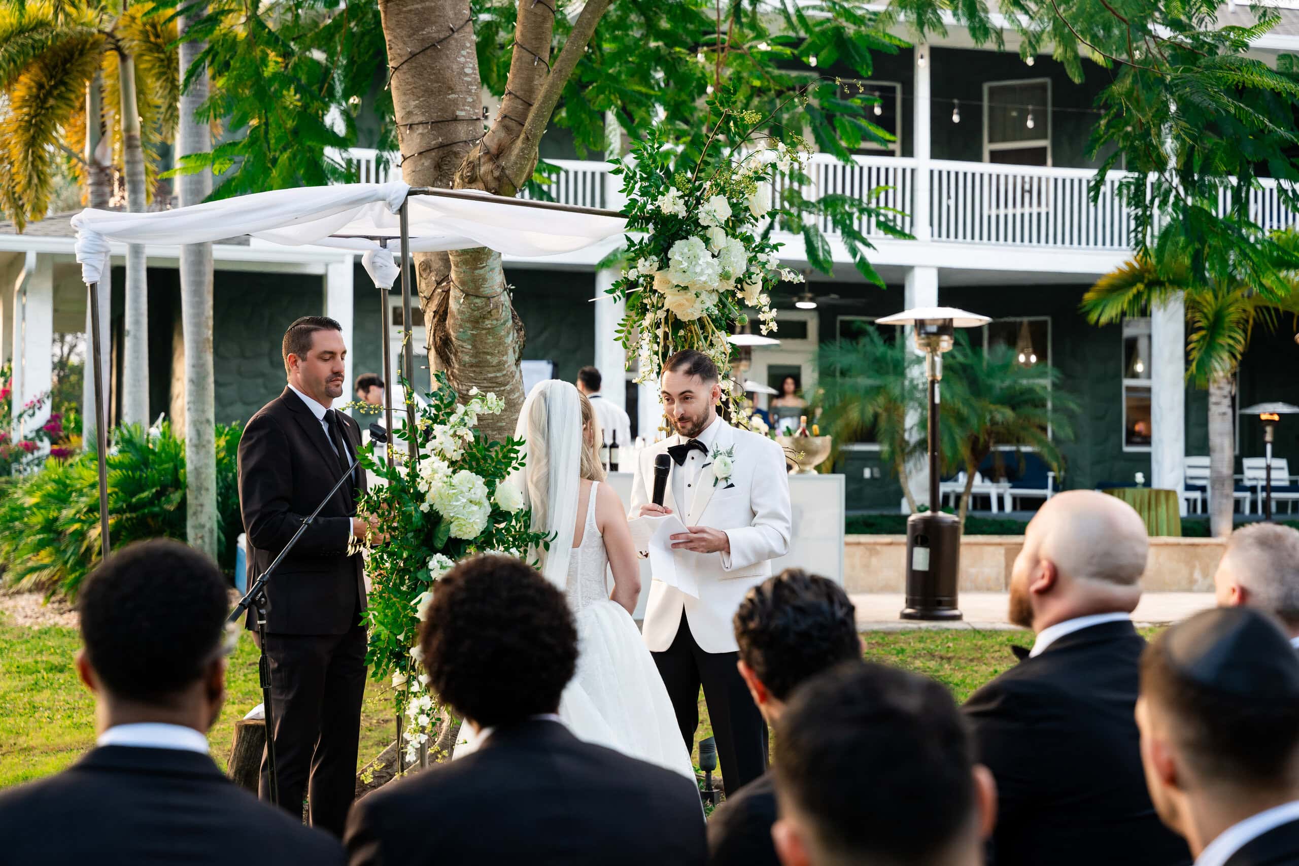 Couple exchanging vows at an outdoor private estate wedding ceremony in South Florida.