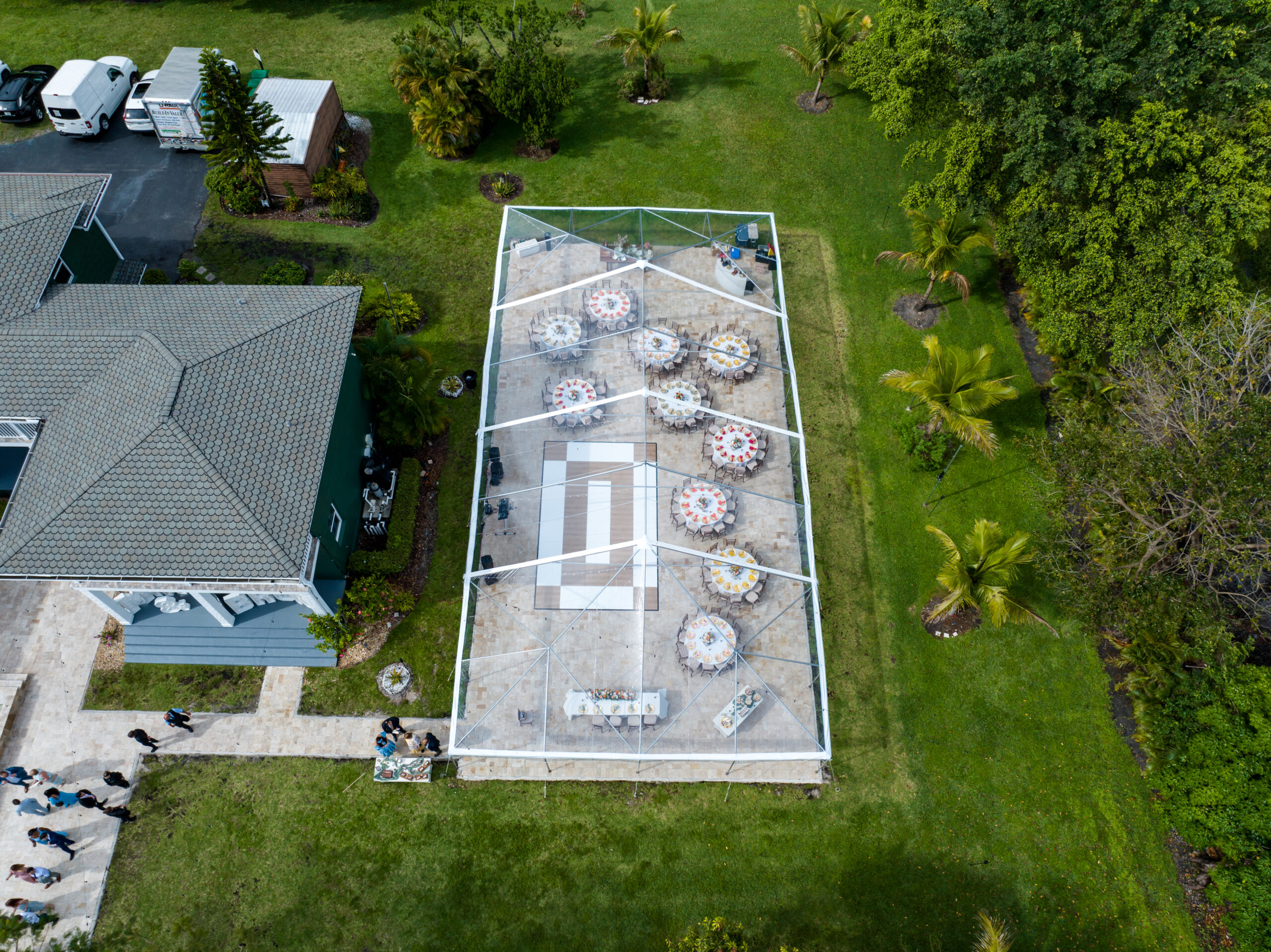 Aerial view of an elegant outdoor tented reception setup for a lovely wedding with tables and dance floor.