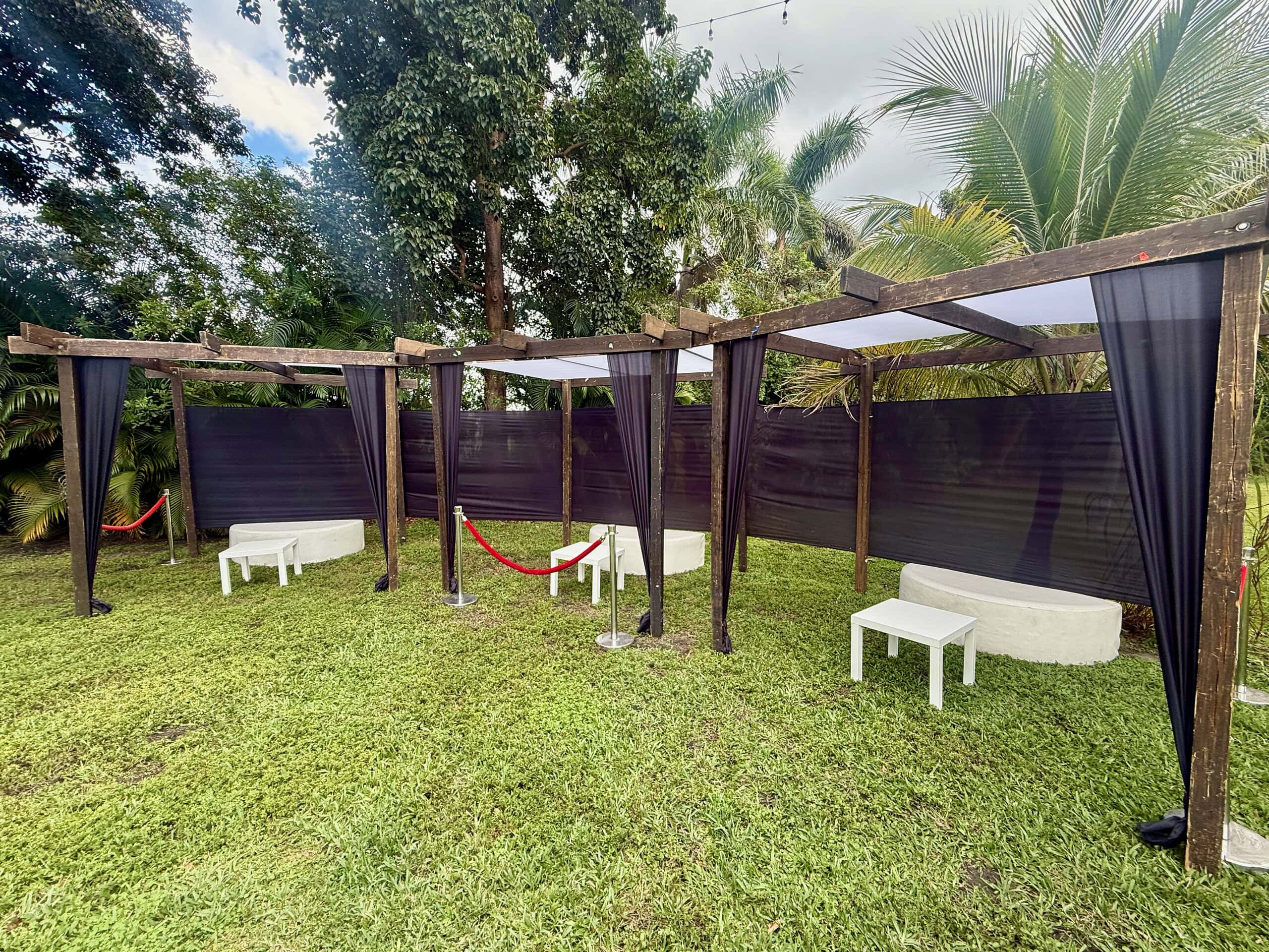 Outdoor VIP lounge seating with pergola structures and velvet rope entry at Saint Patrick Palace.