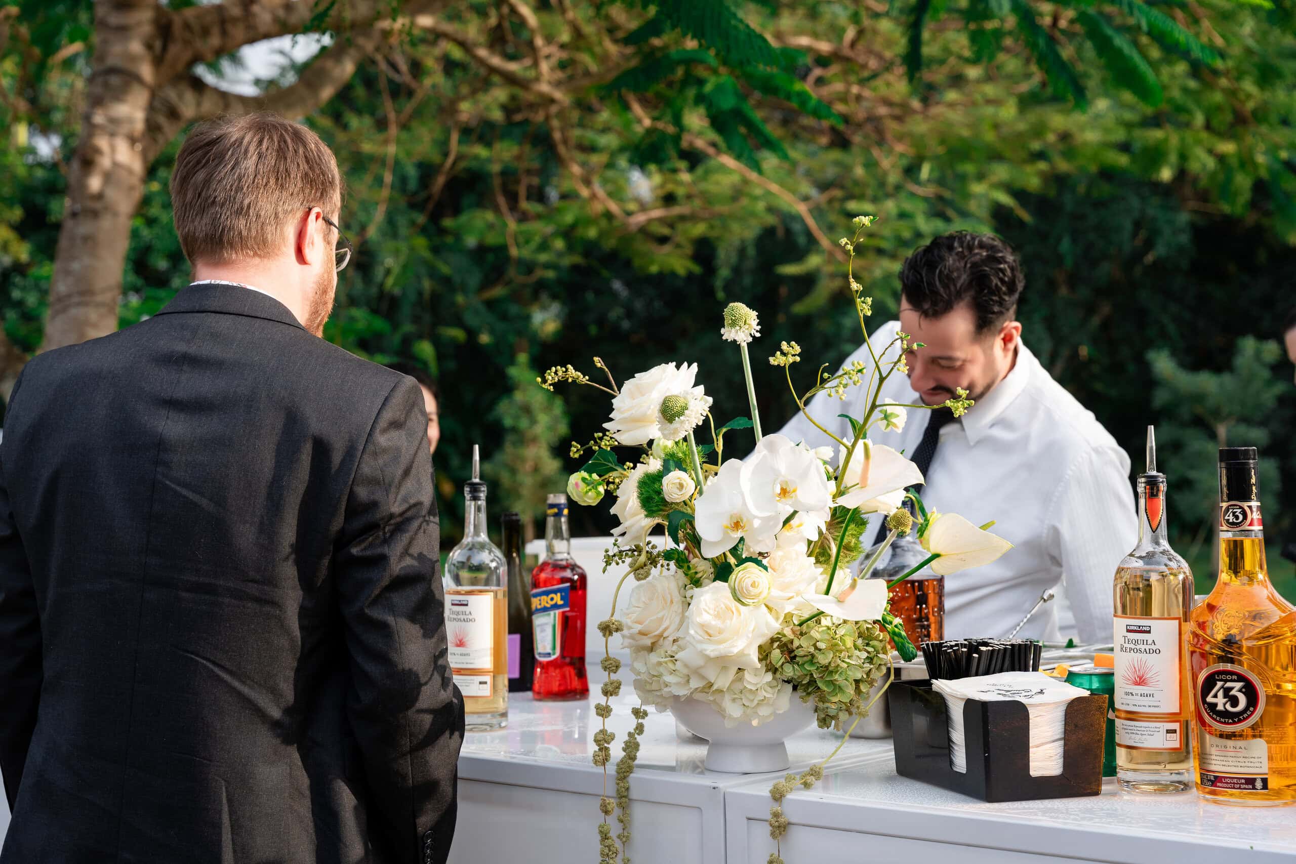 Elegant outdoor wedding bar with floral décor and handcrafted cocktails during cocktail hour at Saint Patrick Palace.