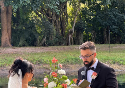 Groom reading vows during an outdoor wedding ceremony by the water at Saint Patrick Palace.