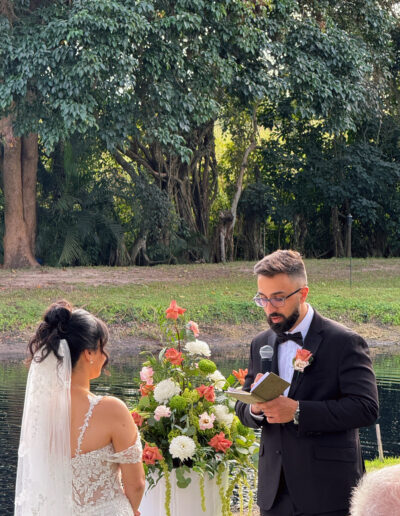 Groom reading vows during an outdoor wedding ceremony by the water at Saint Patrick Palace.