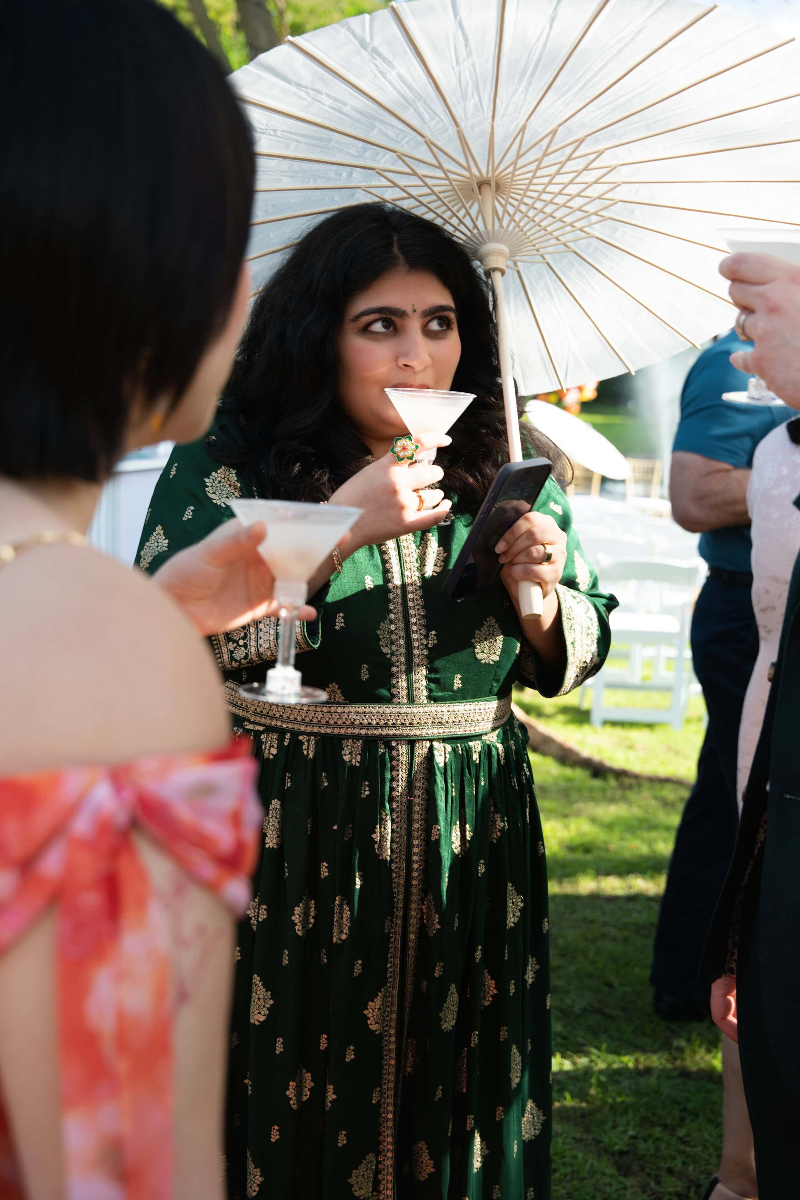 Wedding guest enjoying a handcrafted cocktail during an outdoor cocktail hour at a unique South Florida wedding venue.