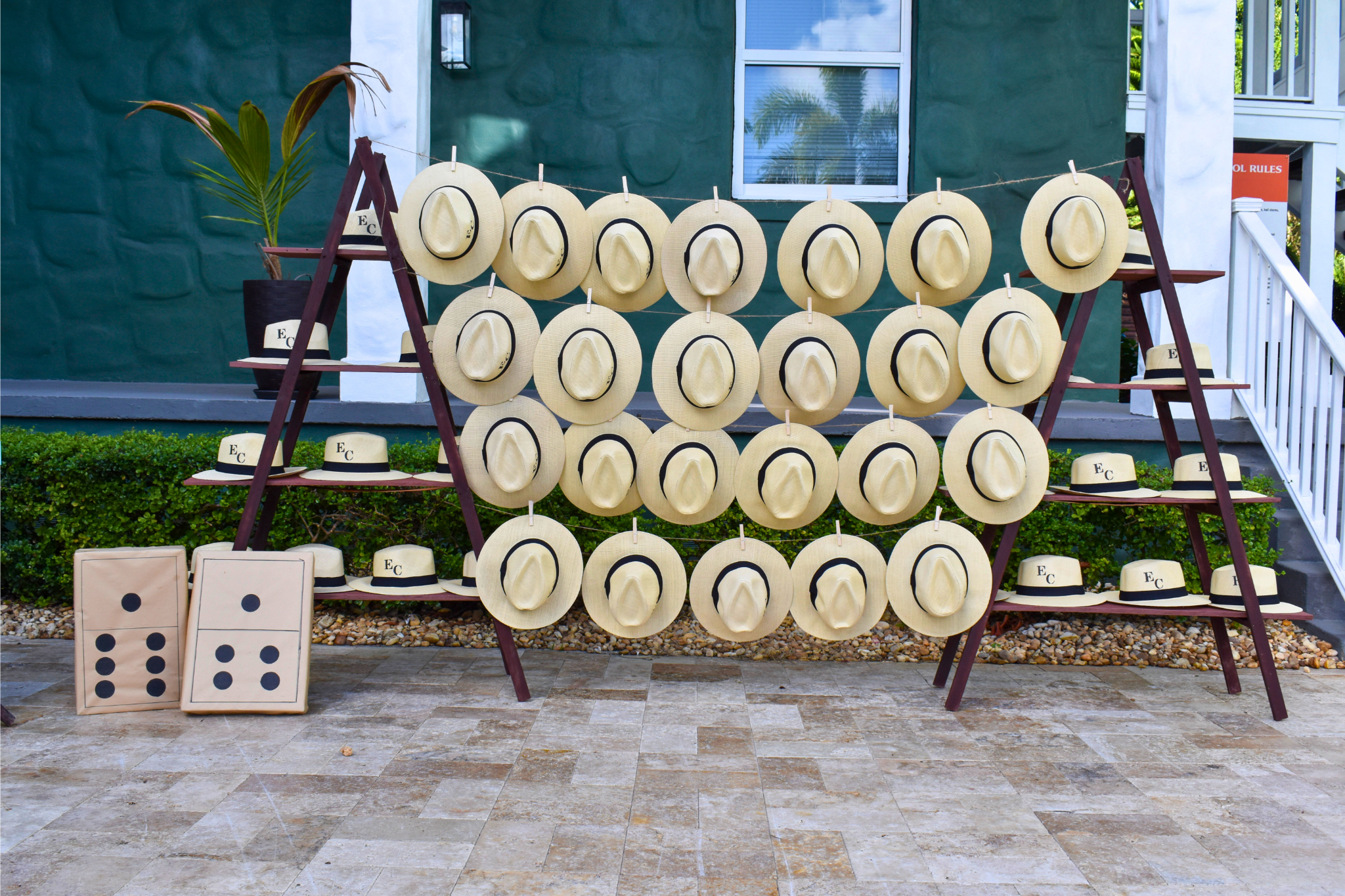 Panama hat wall display with personalized party favors for outdoor milestone celebrations.