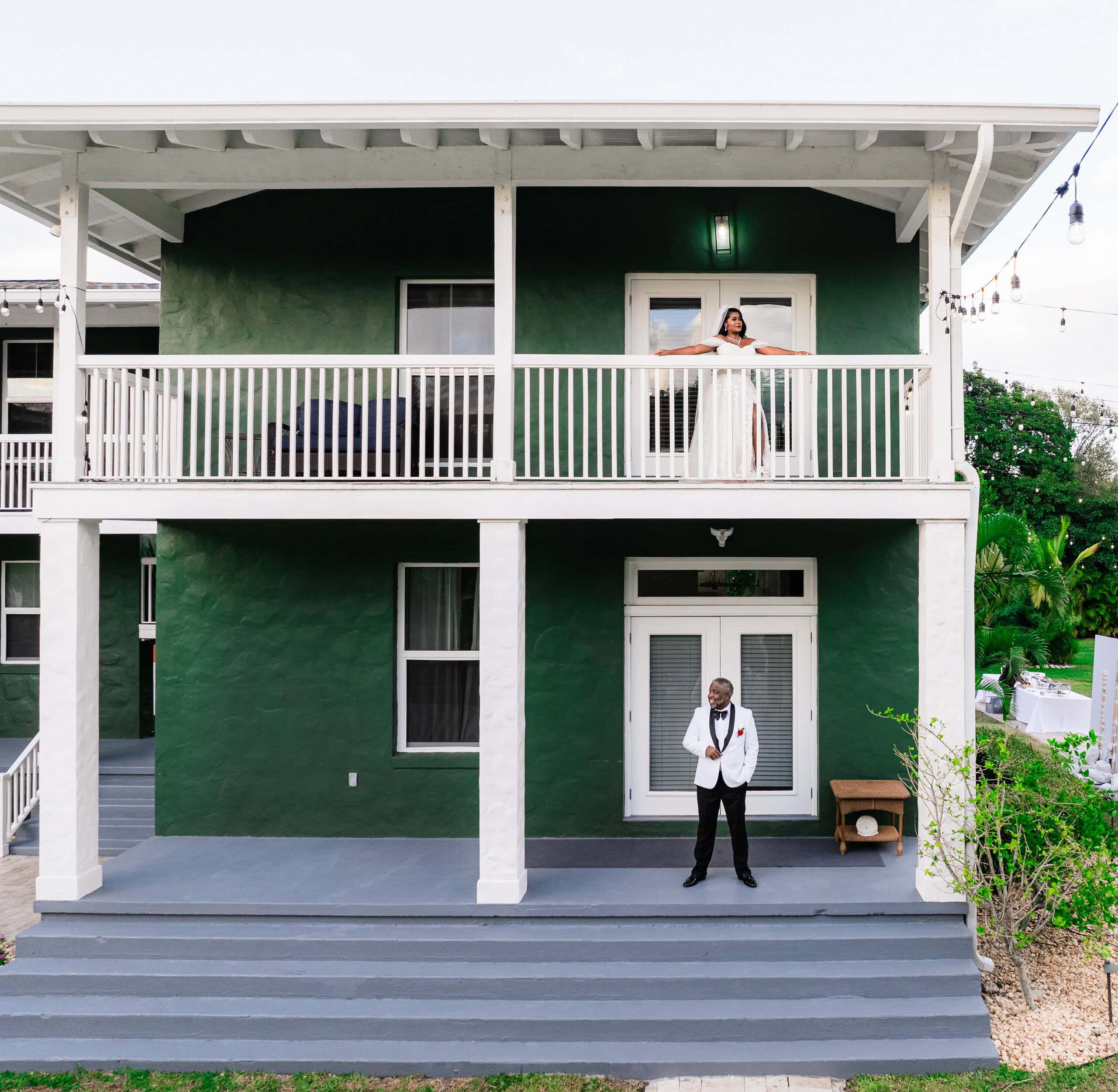 Bride on balcony and groom below at private estate residence Saint Patrick Palace South Florida wedding setting