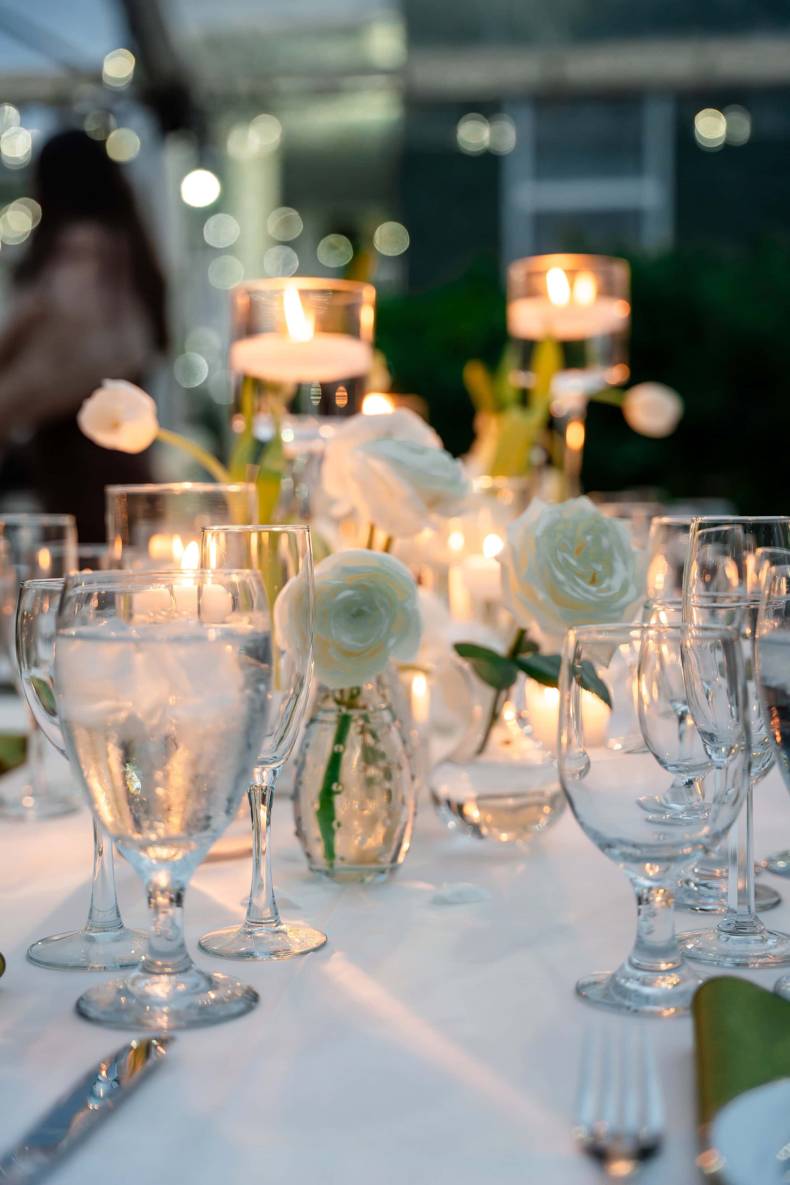 Candlelit reception table with white roses at a private estate wedding in South Florida.
