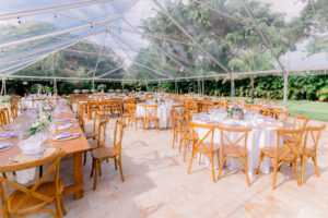 Clear tent outdoor reception with wood chairs, pastel florals, and summer greenery at Saint Patrick Palace.