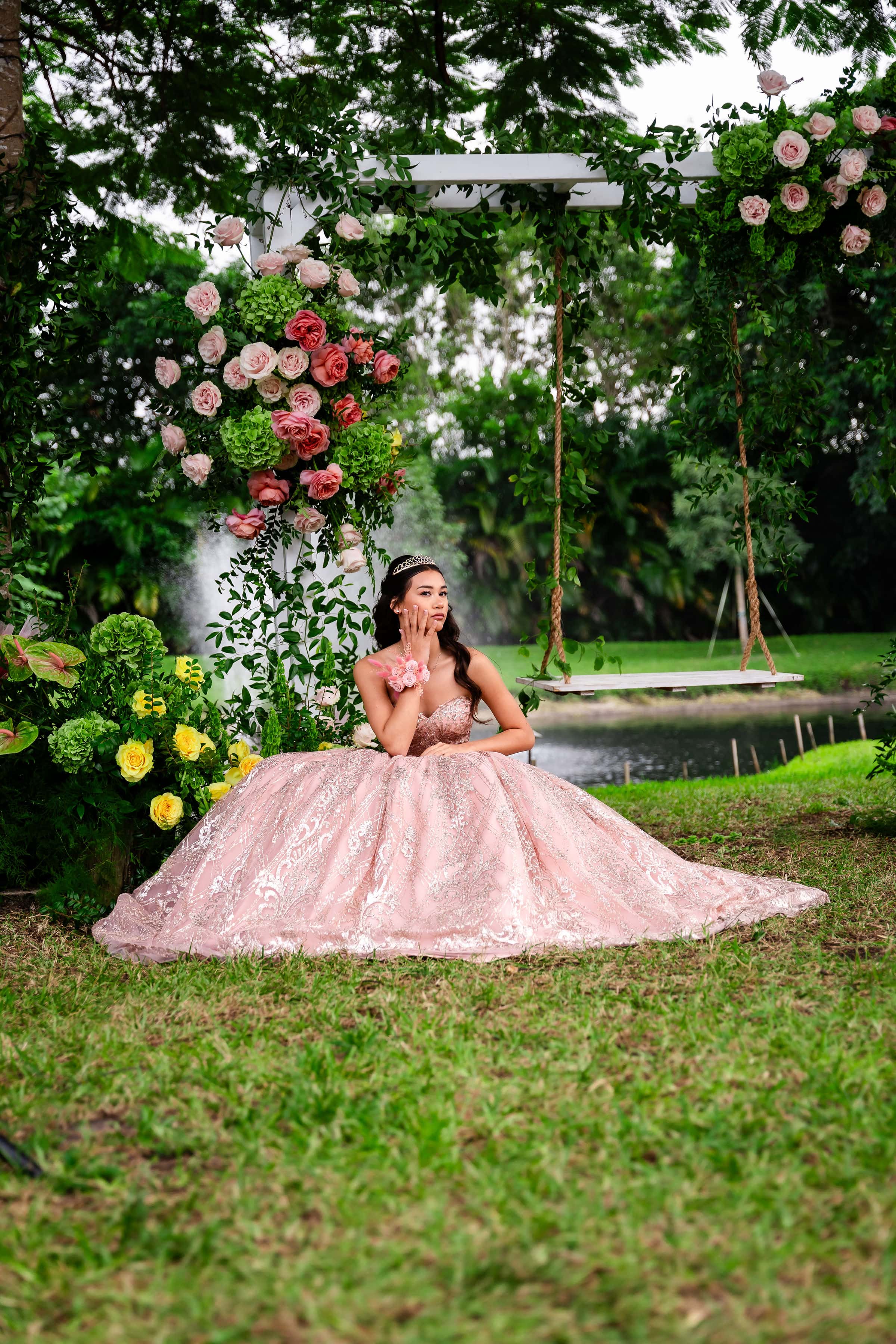 Quinceañera celebration with floral swing and blush gown at a private estate garden in South Florida by the water