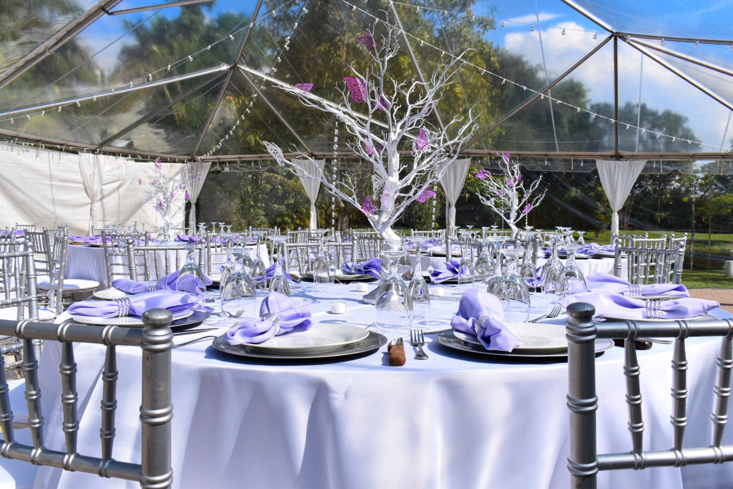 Elegant quinceañera table décor with lilac napkins and silver chairs at South Florida event venue.