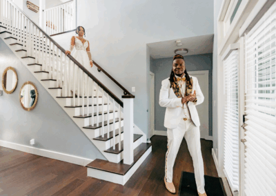 Bride walks down staircase for a romantic first look with the groom inside a private estate wedding venue.