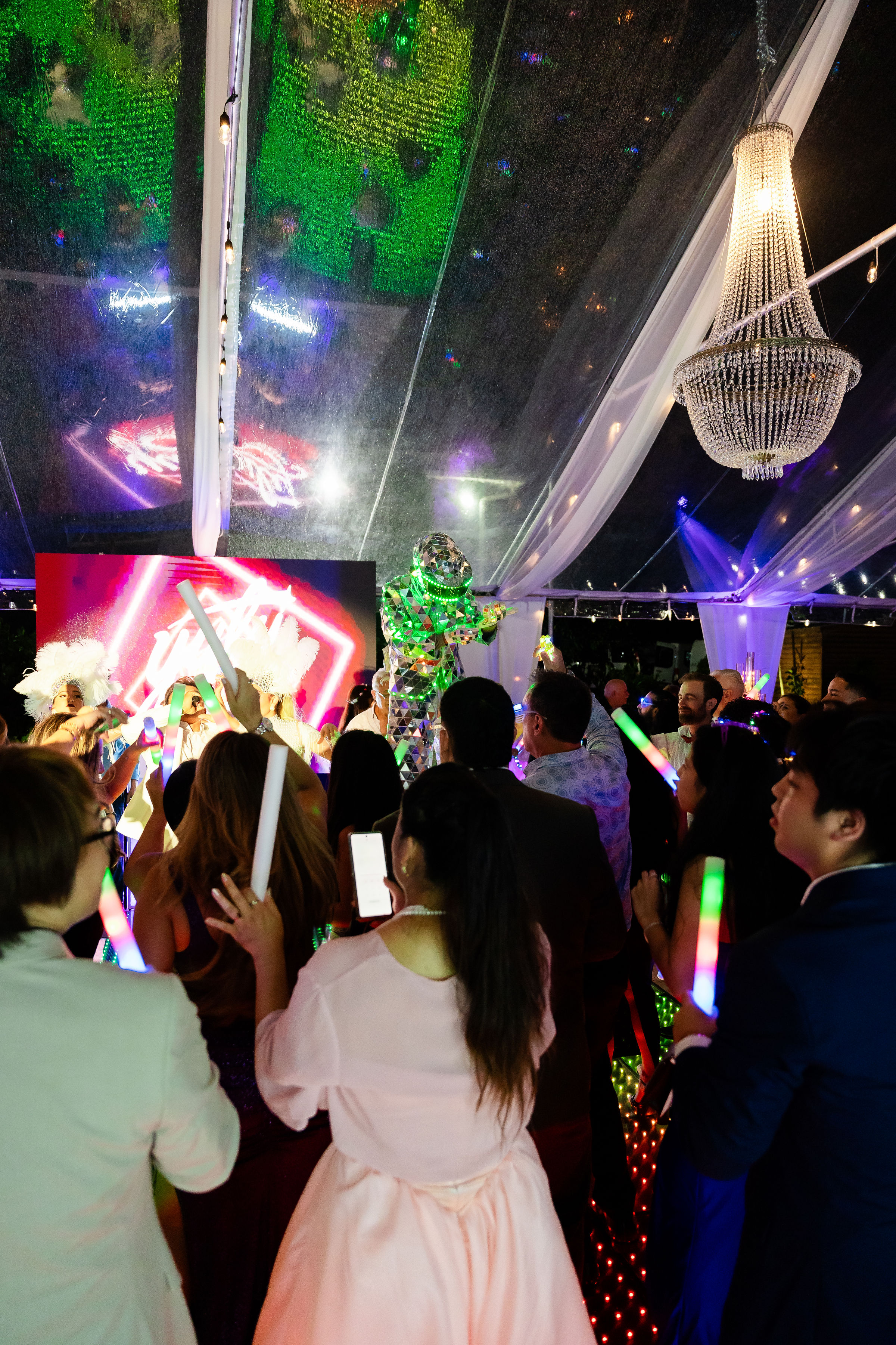 Guests dancing under neon lights and LED effects during a quinceañera celebration at Saint Patrick Palace.
