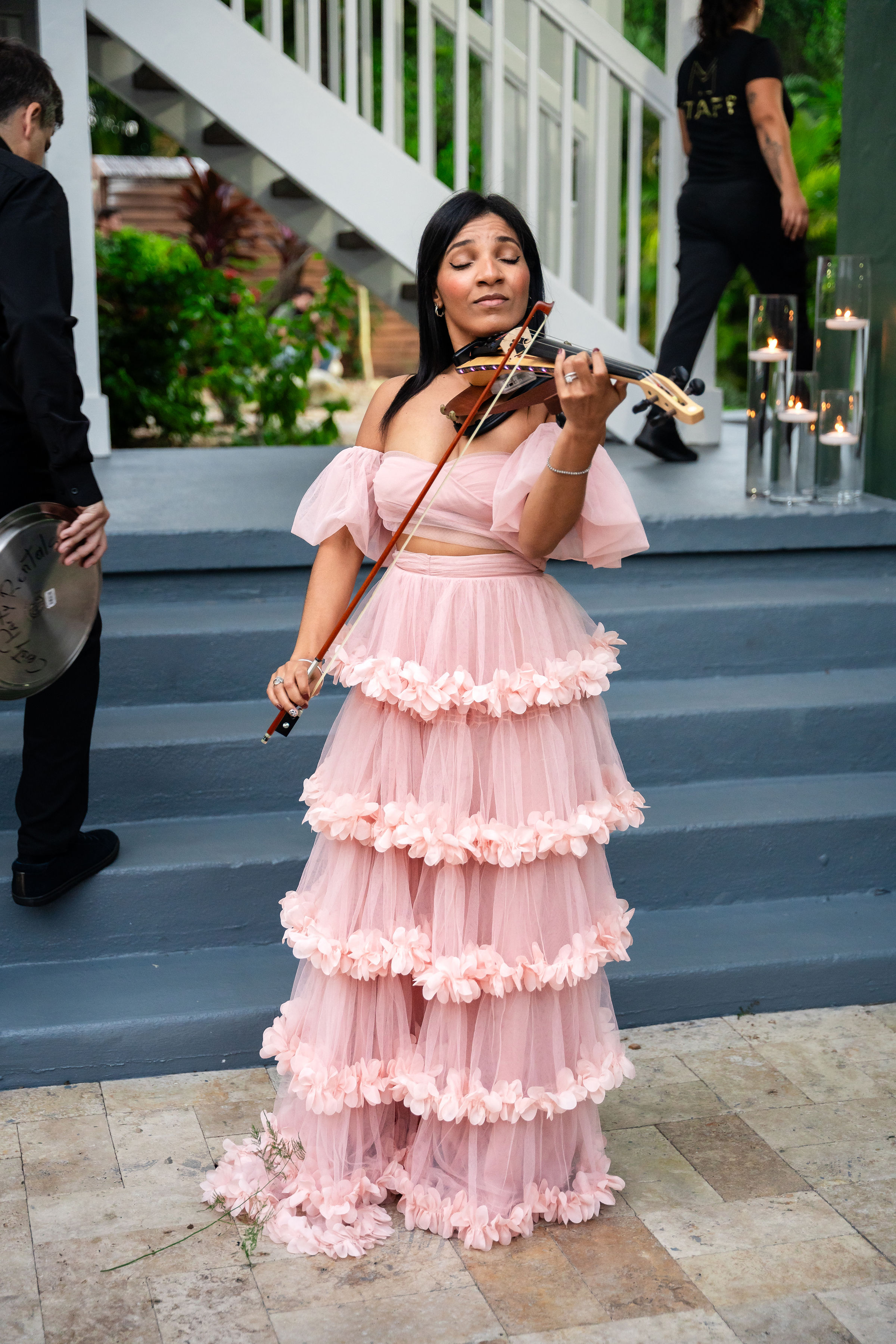Violinist in a blush floral gown performing live at a rose gold quinceañera at Saint Patrick Palace.