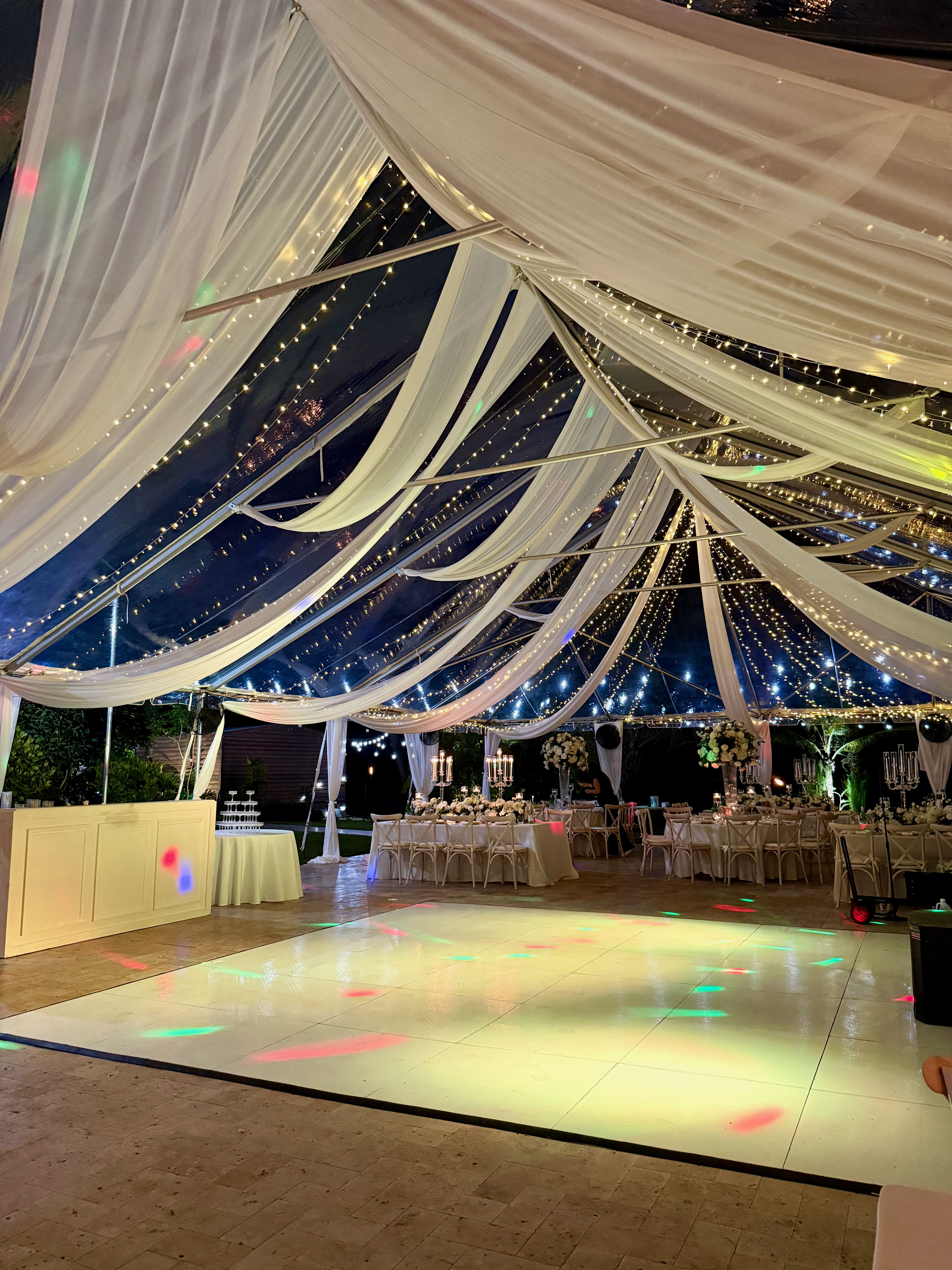 Clear tent wedding reception with draped fabric and dance floor during an elevated wedding weekend at Saint Patrick Palace.