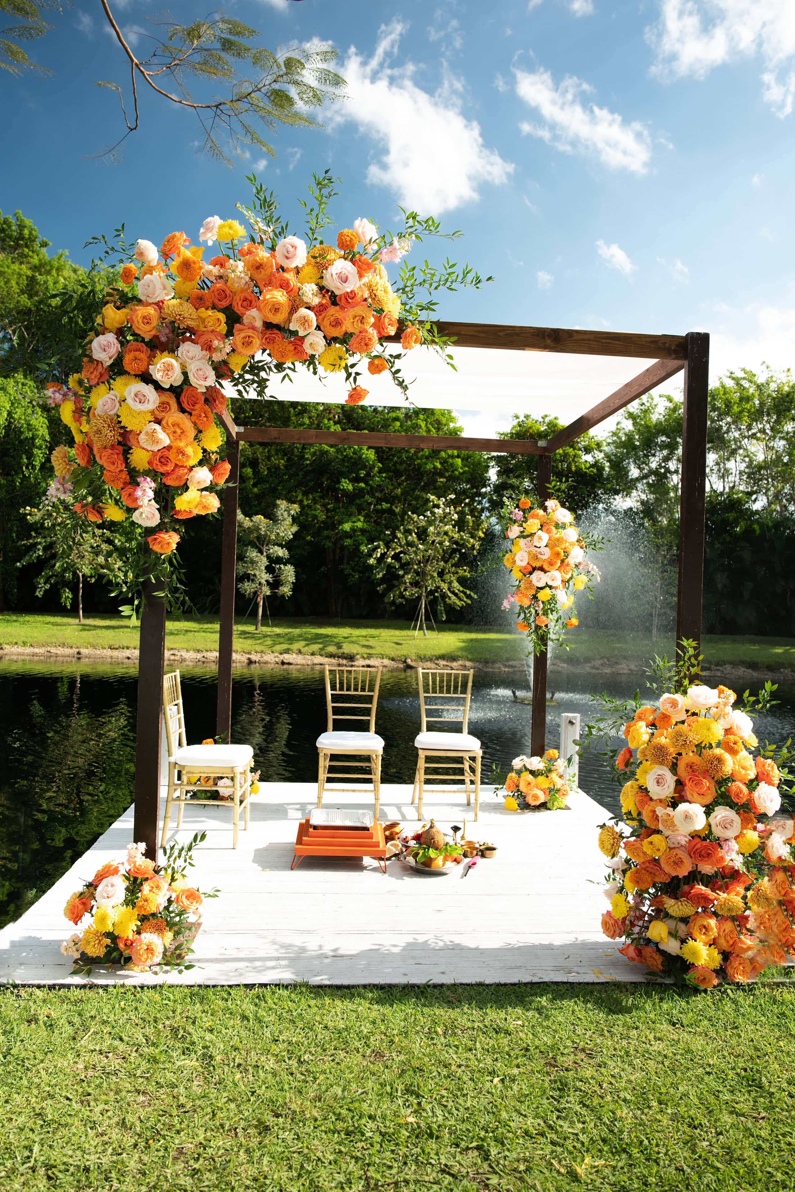 Floral mandap overlooking the lake during an outdoor Indian wedding ceremony at Saint Patrick Palace in South Florida.