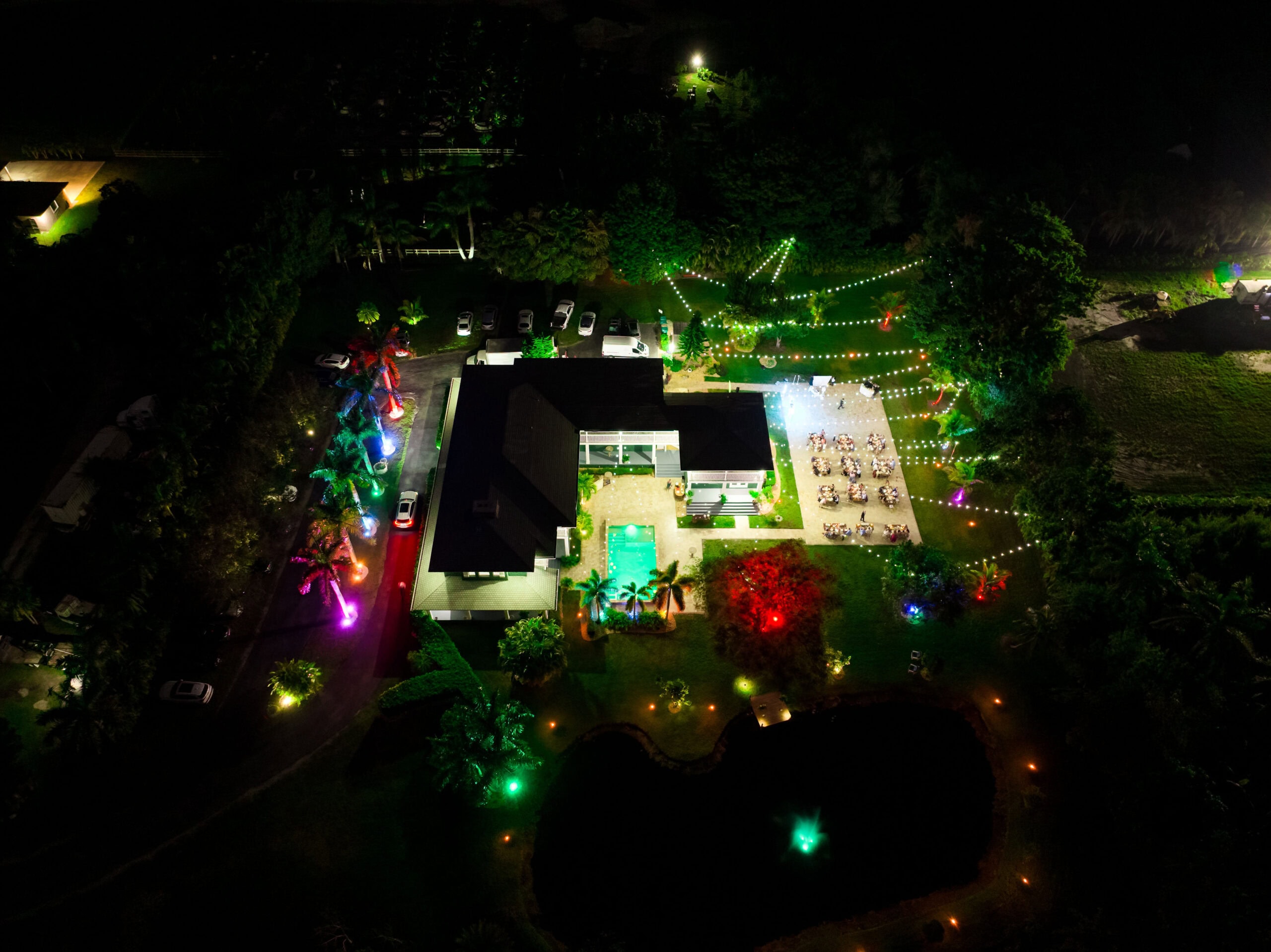 Nighttime Aerial Wedding at Saint Patrick Palace | South Florida Estate Venue Nighttime aerial view of Saint Patrick Palace wedding estate with glowing lights and pool in Davie, Florida"