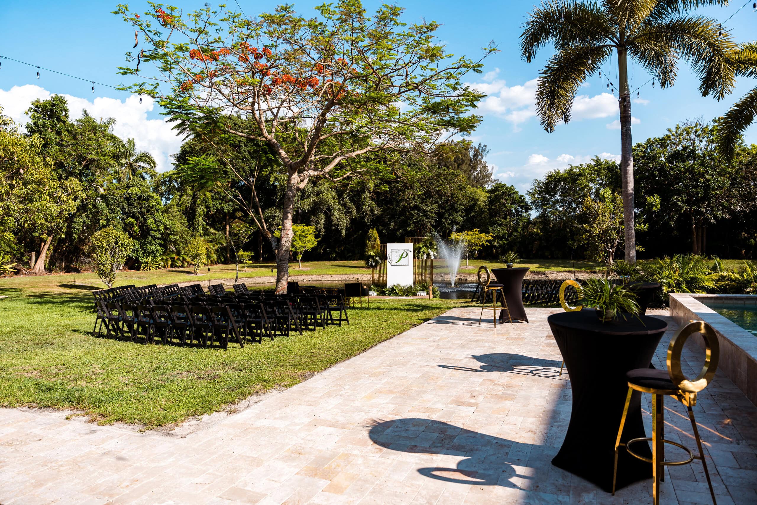 Outdoor wedding cocktail hour patio with high top tables at Saint Patrick Palace private estate in South Florida