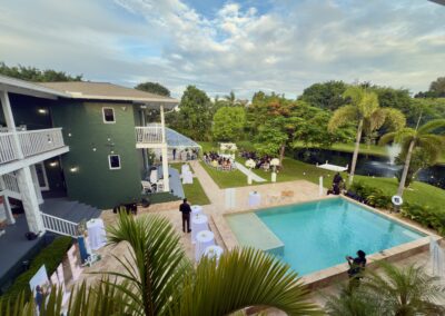 Elegant poolside view of Saint Patrick Palace with garden ceremony and lakefront fountain backdrop.