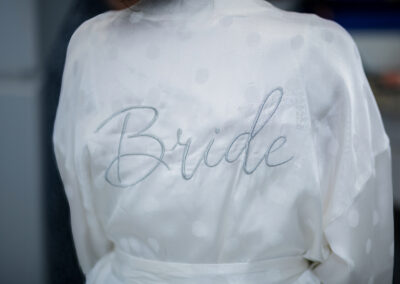 Bride in custom robe and gown in bridal suite at South Florida Airbnb wedding venue, Saint Patrick Palace