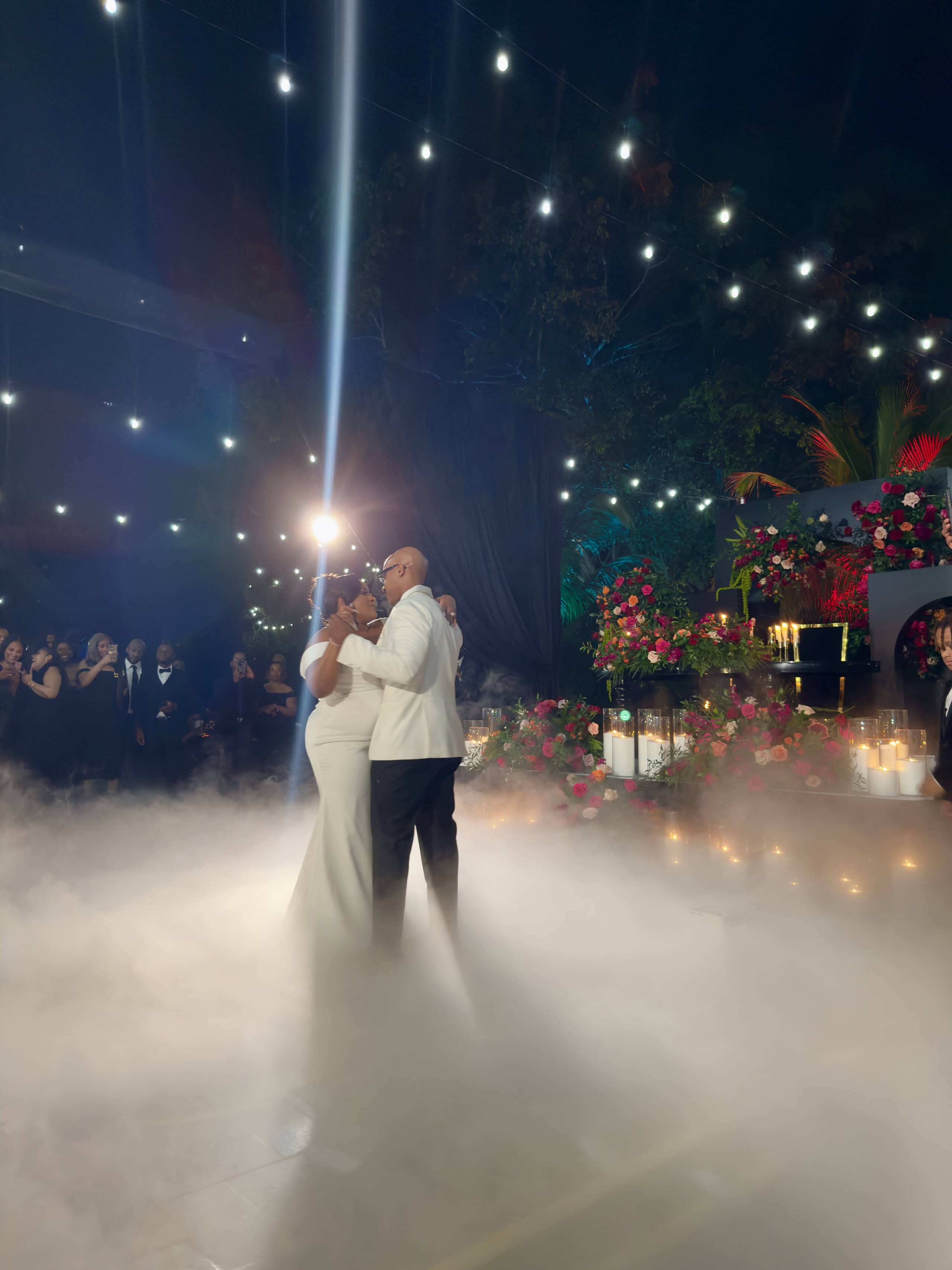 Black-tie garden wedding first dance under café lights at a luxury South Florida estate
