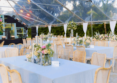 Elegant clear-top tented wedding reception in South Florida with chic florals and luxury event design.