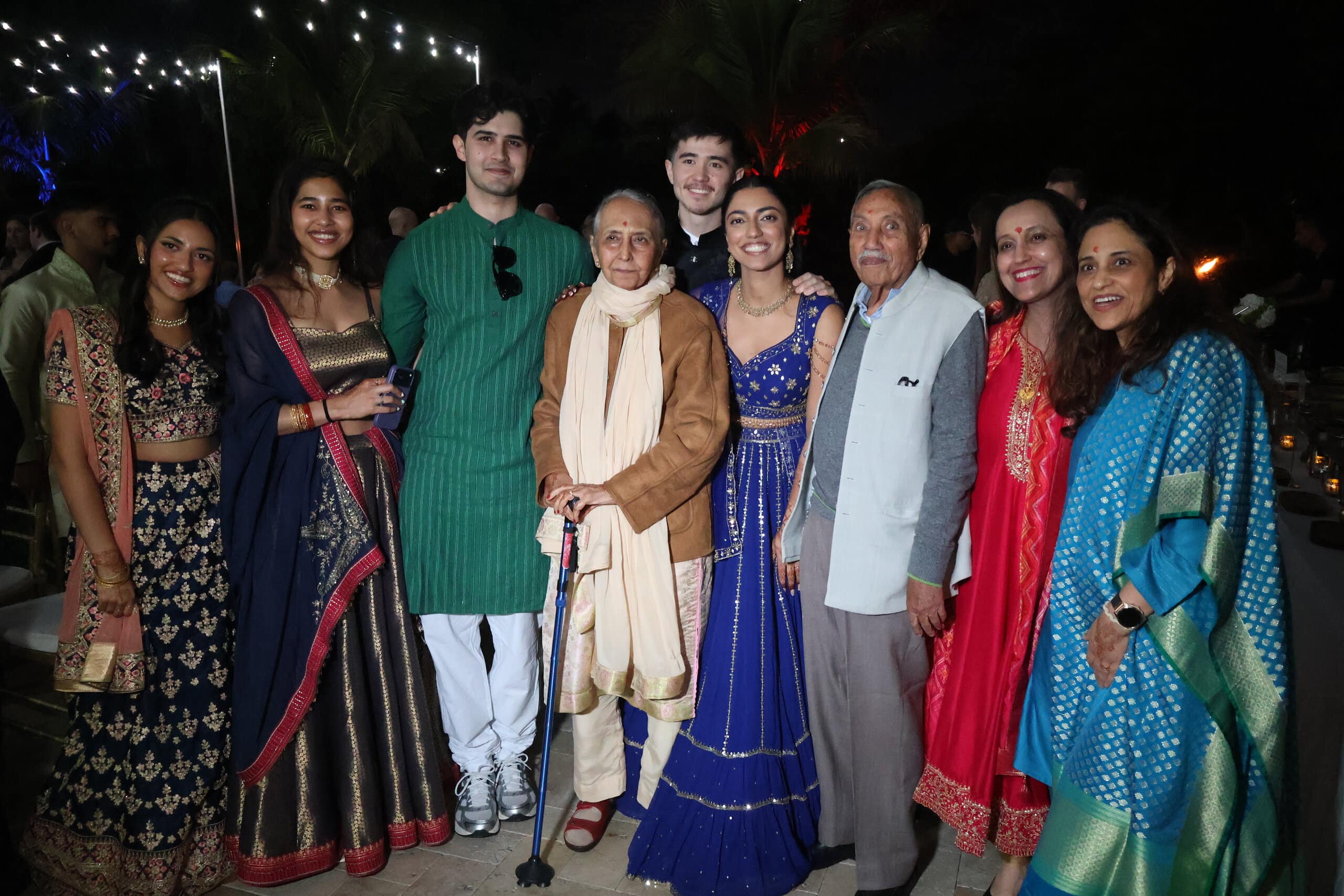 Multigenerational family gathering in traditional attire at an outdoor South Florida wedding celebration.
