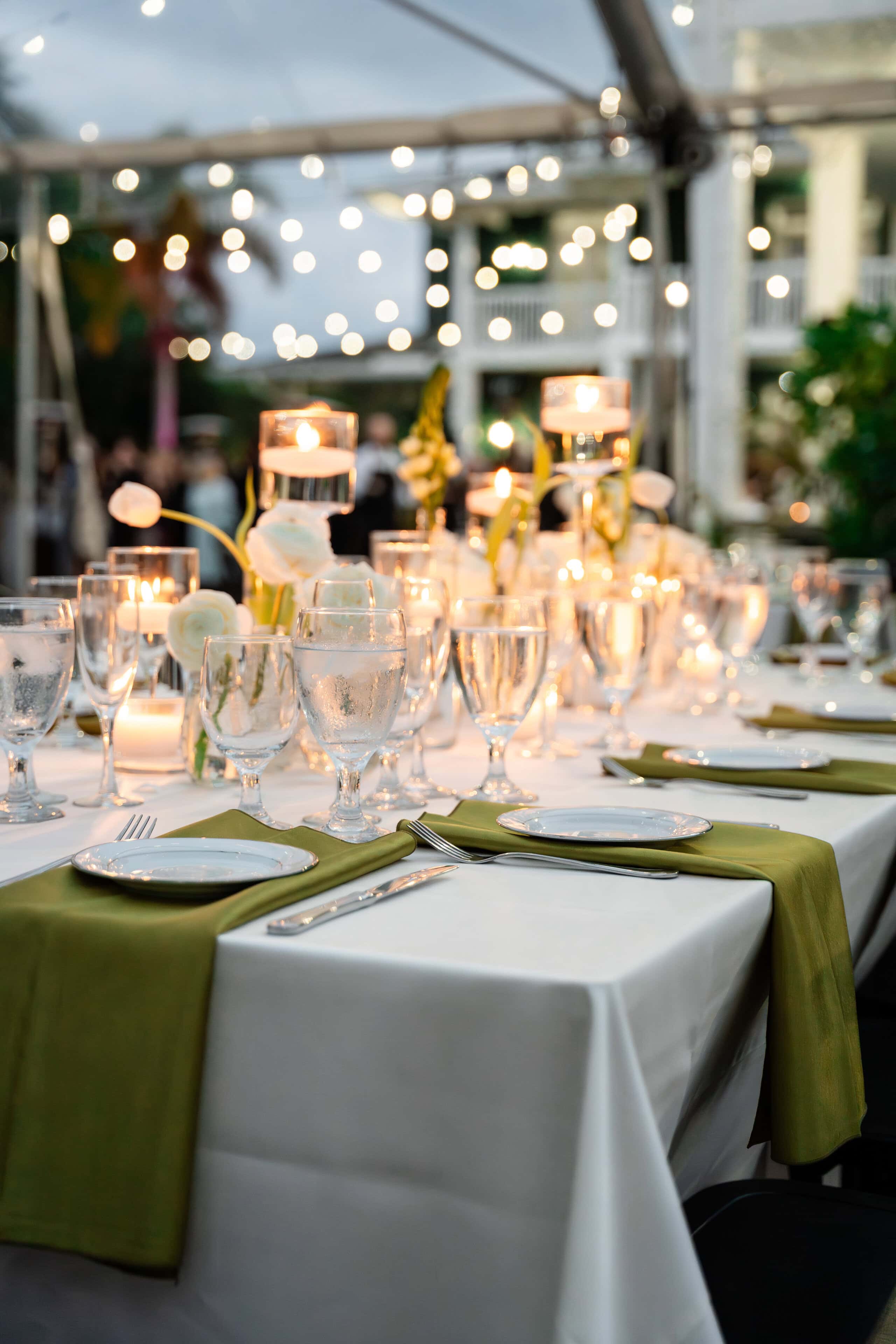 Candlelit wedding reception table beneath a clear-top tent at a South Florida private estate.