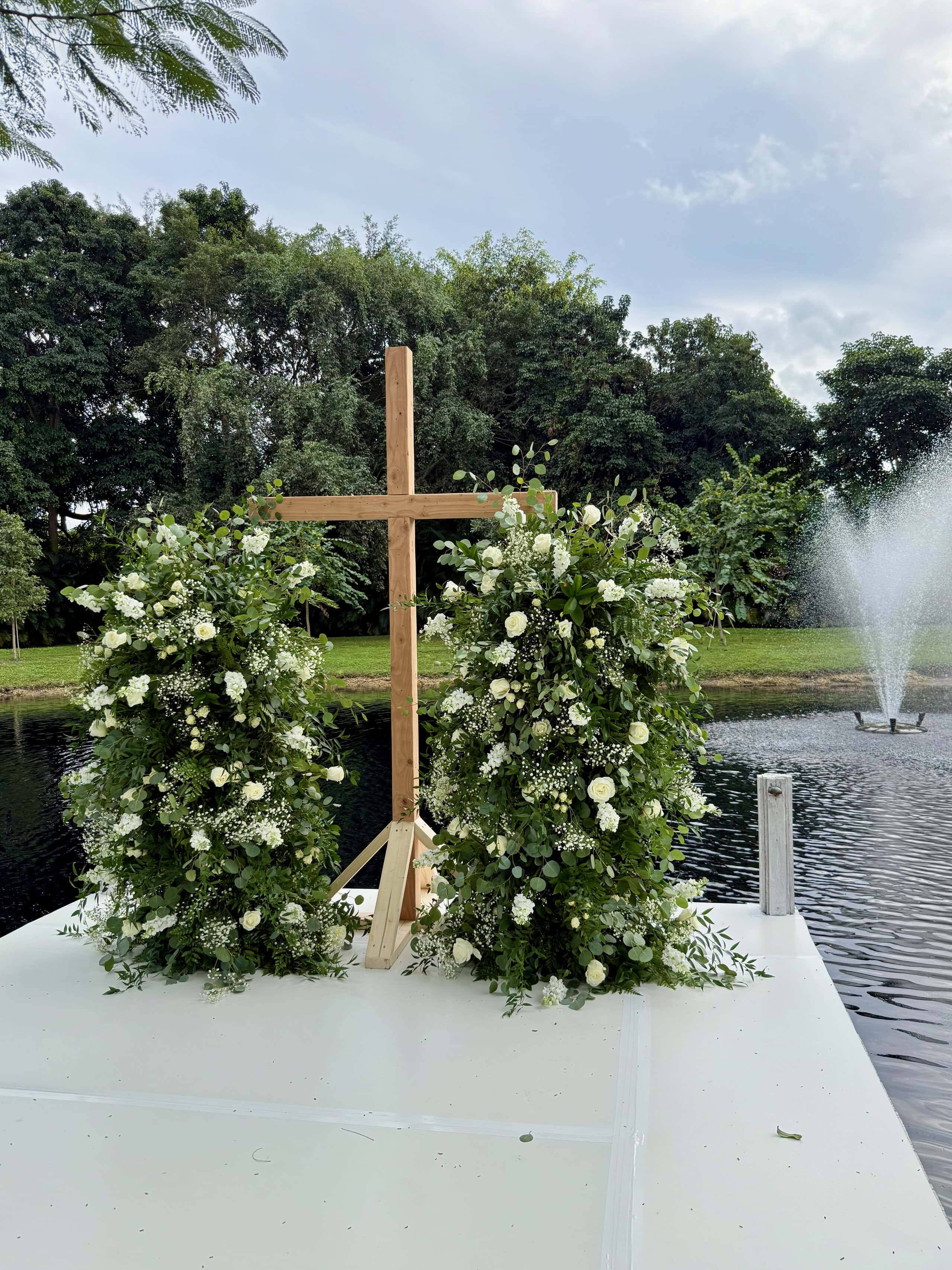Water reflection of ceremony dock and floral details at waterfront wedding venue Saint Patrick Palace in South Florida