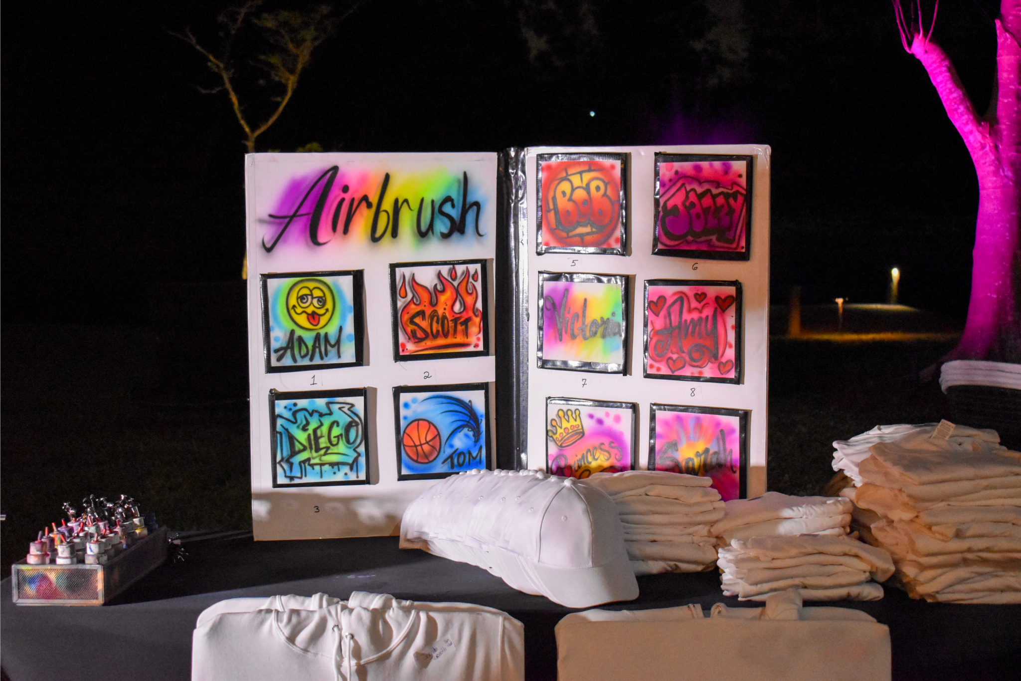 Airbrush station with colorful designs for custom Sweet 16 party favors at a private estate celebration.