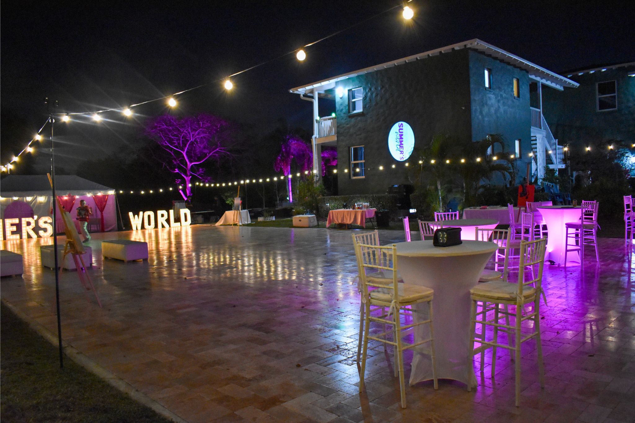 Elegant Sweet 16 setup with glowing tables, string lights, and marquee letters at a private estate.
