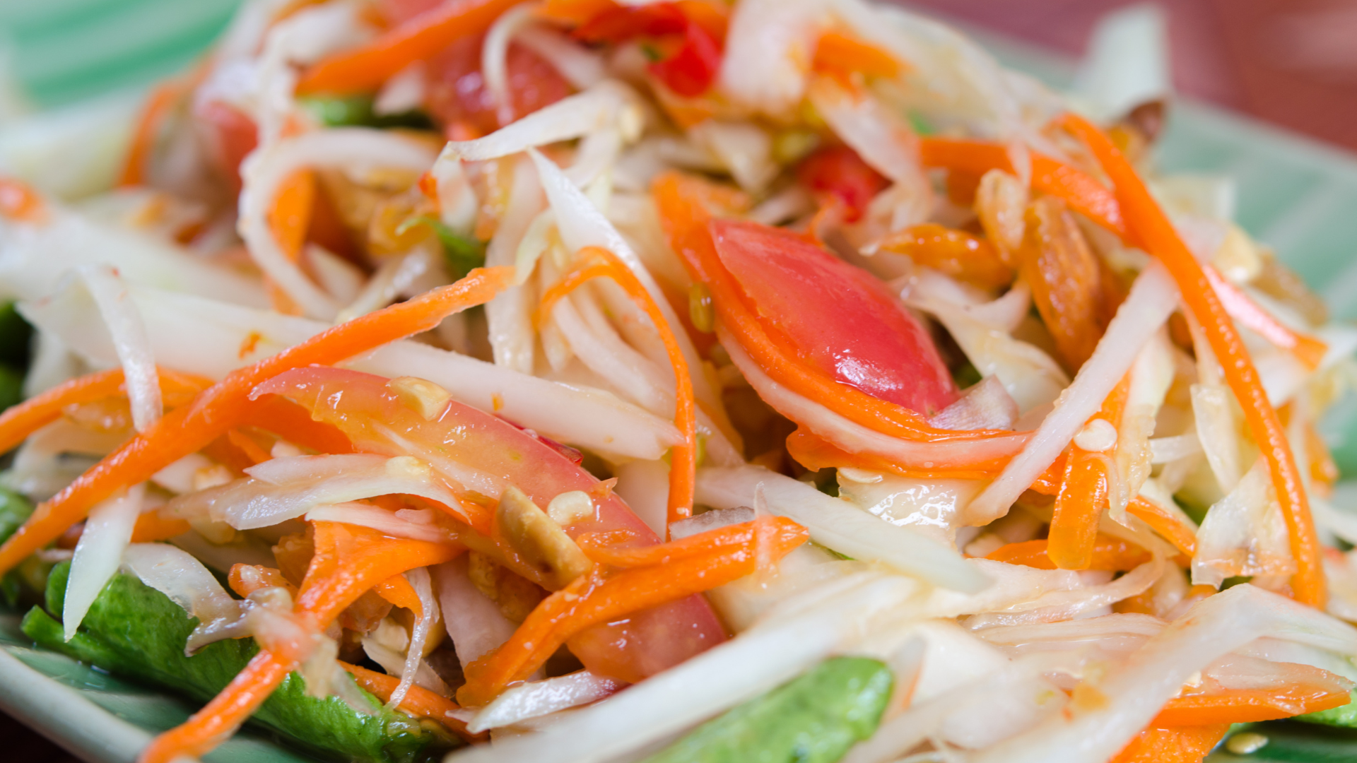 Thai green papaya salad with shredded papaya, carrots, tomatoes, and peanuts for a wedding reception.