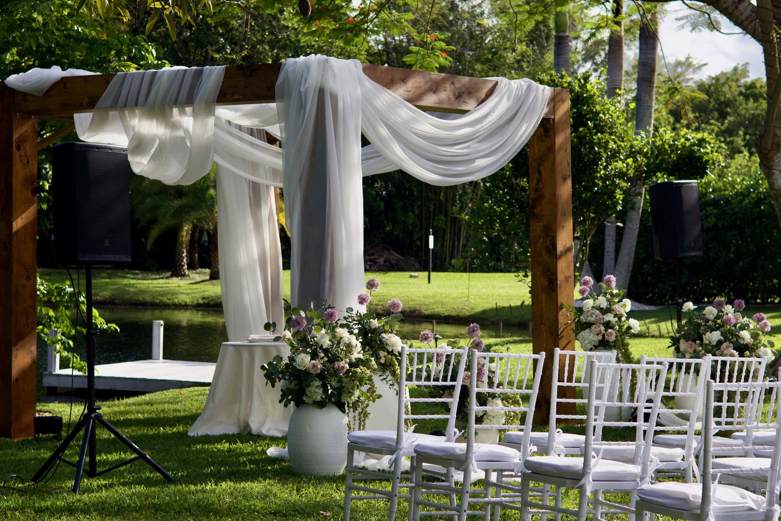 Elegant waterfront Jewish wedding ceremony with a floral chuppah at Saint Patrick Palace in South Florida.