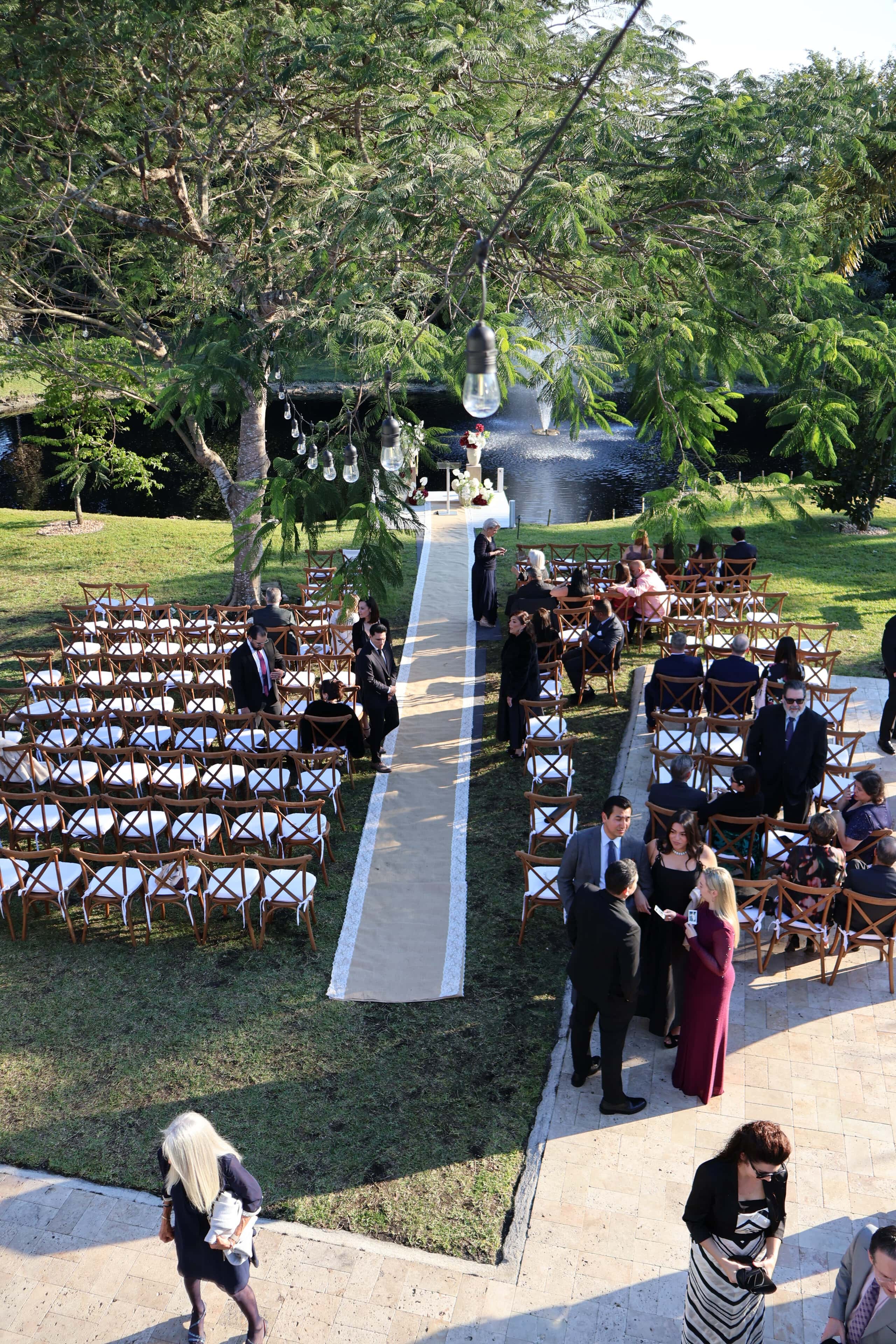 Outdoor wedding ceremony setup by waterside dock with aisle seating at Saint Patrick Palace
