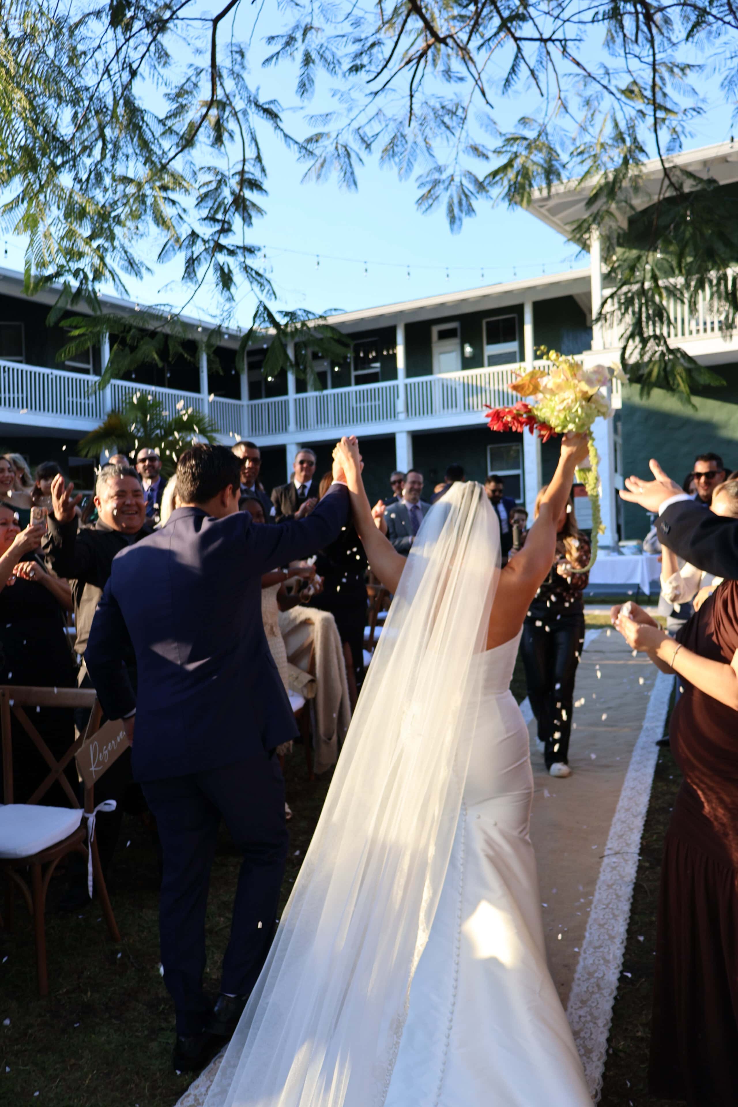 Bride and groom walking down aisle after ceremony with guests celebrating at Saint Patrick Palace