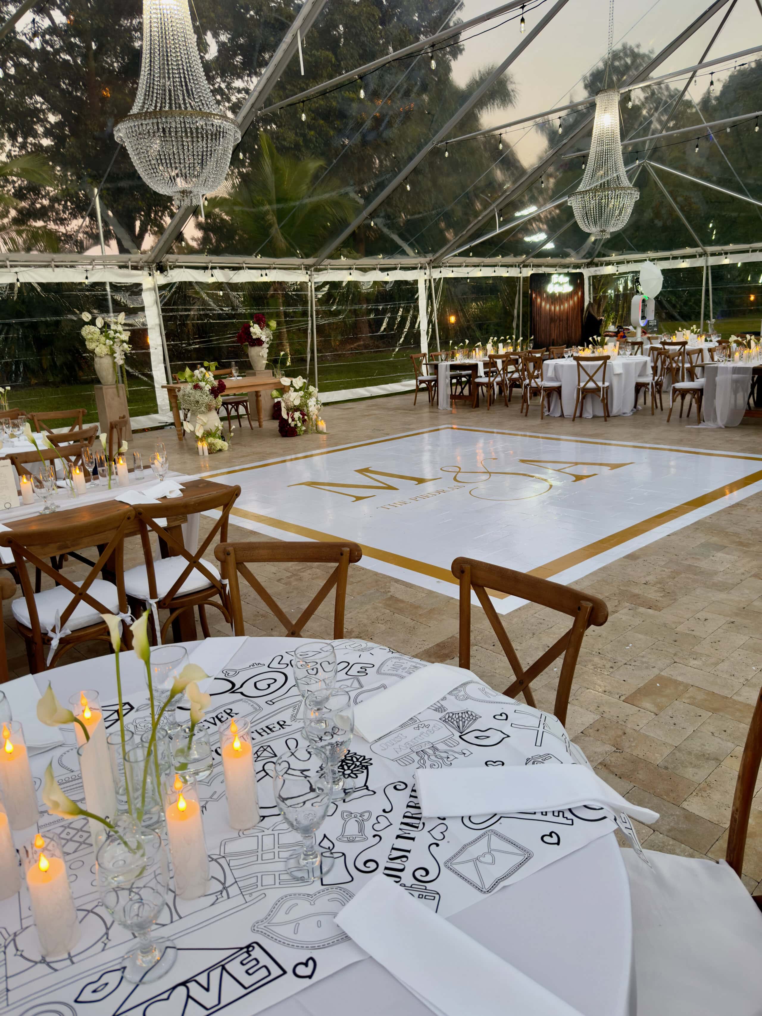 Wedding dance floor with chandeliers under clear tent at Saint Patrick Palace
