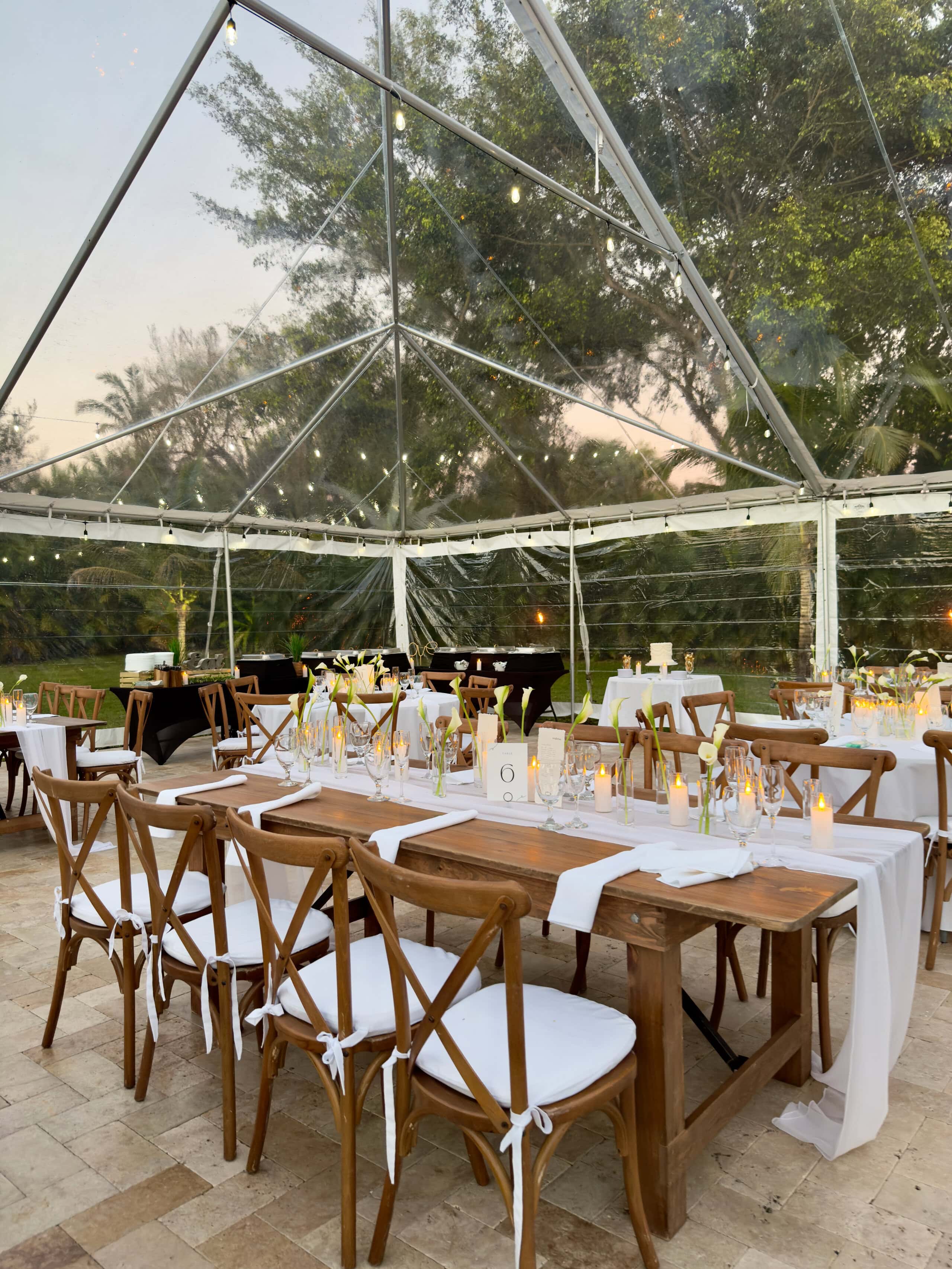 Wedding reception long table setup under clear tent at Saint Patrick Palace