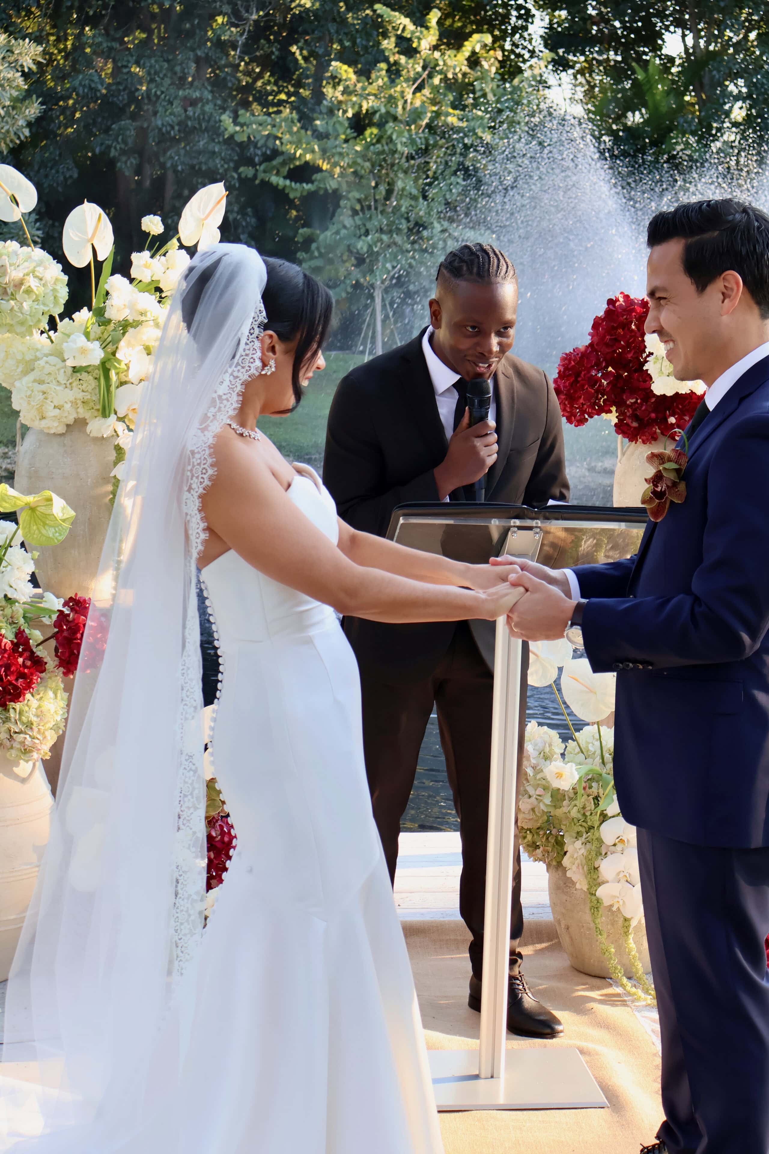 Bride and groom holding hands during their wedding vows at Saint Patrick Palace.