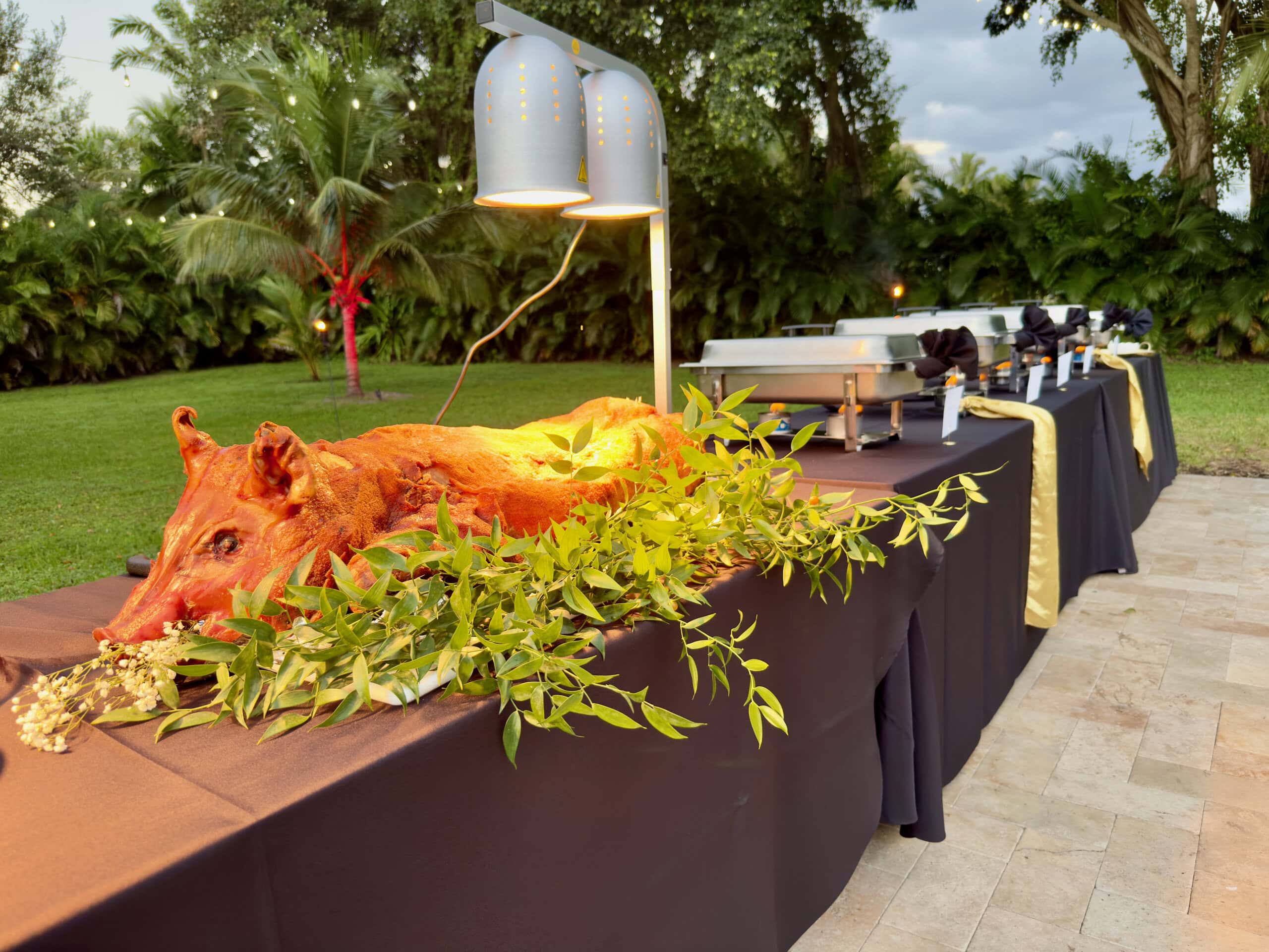 Whole hog carving station at outdoor wedding buffet