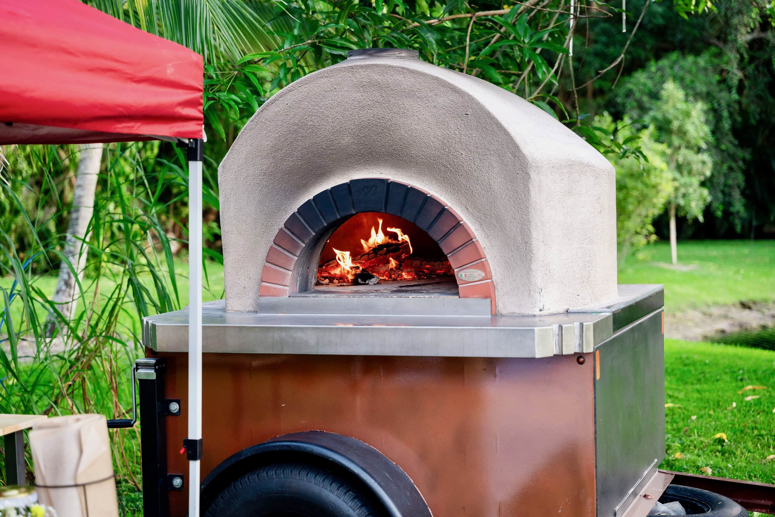 Mobile wood fired pizza oven catering station at outdoor event